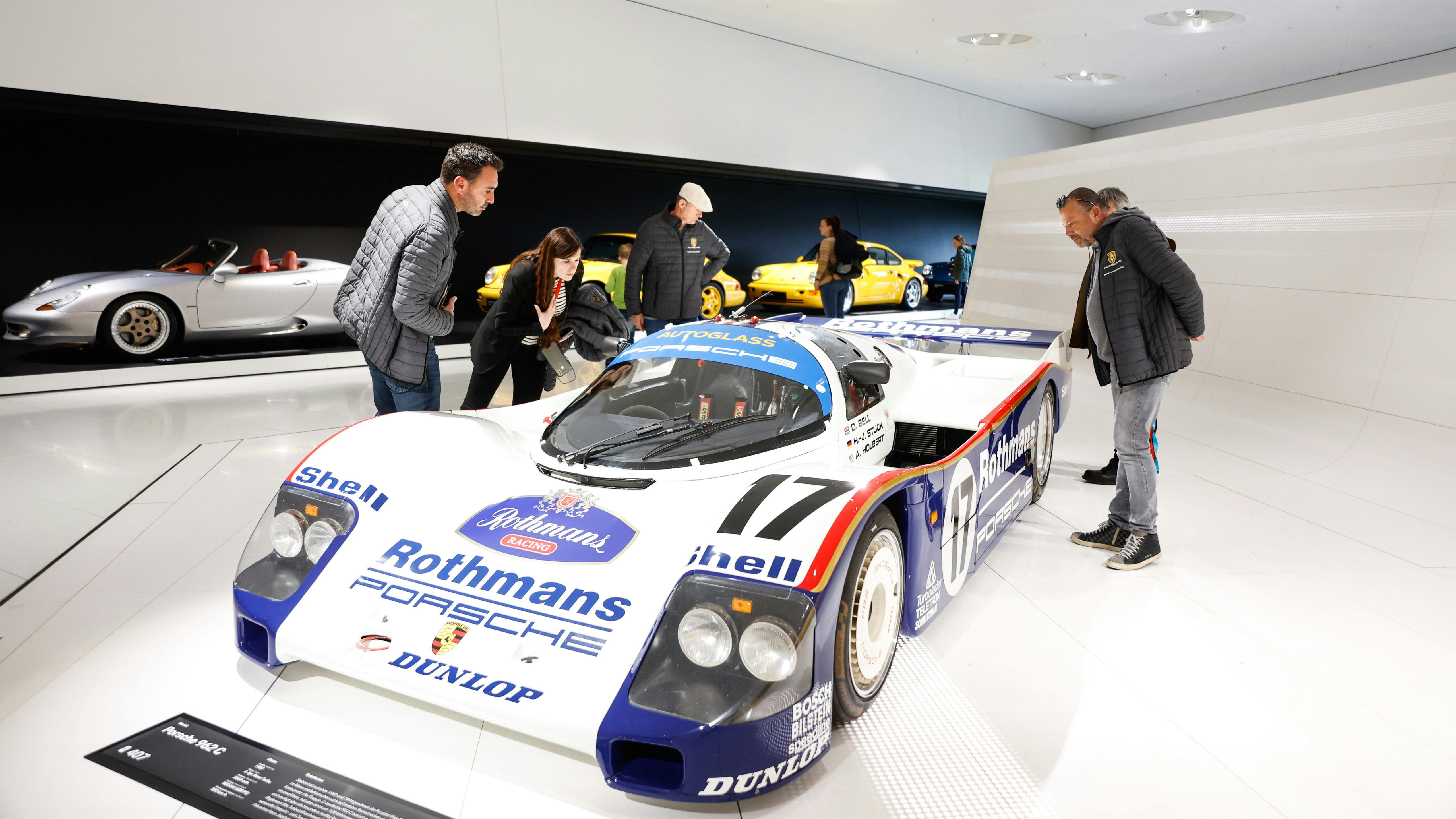 Les finalistes du Concours de Restauration regardent une voiture de course au musée Porsche de Zuffenhausen.