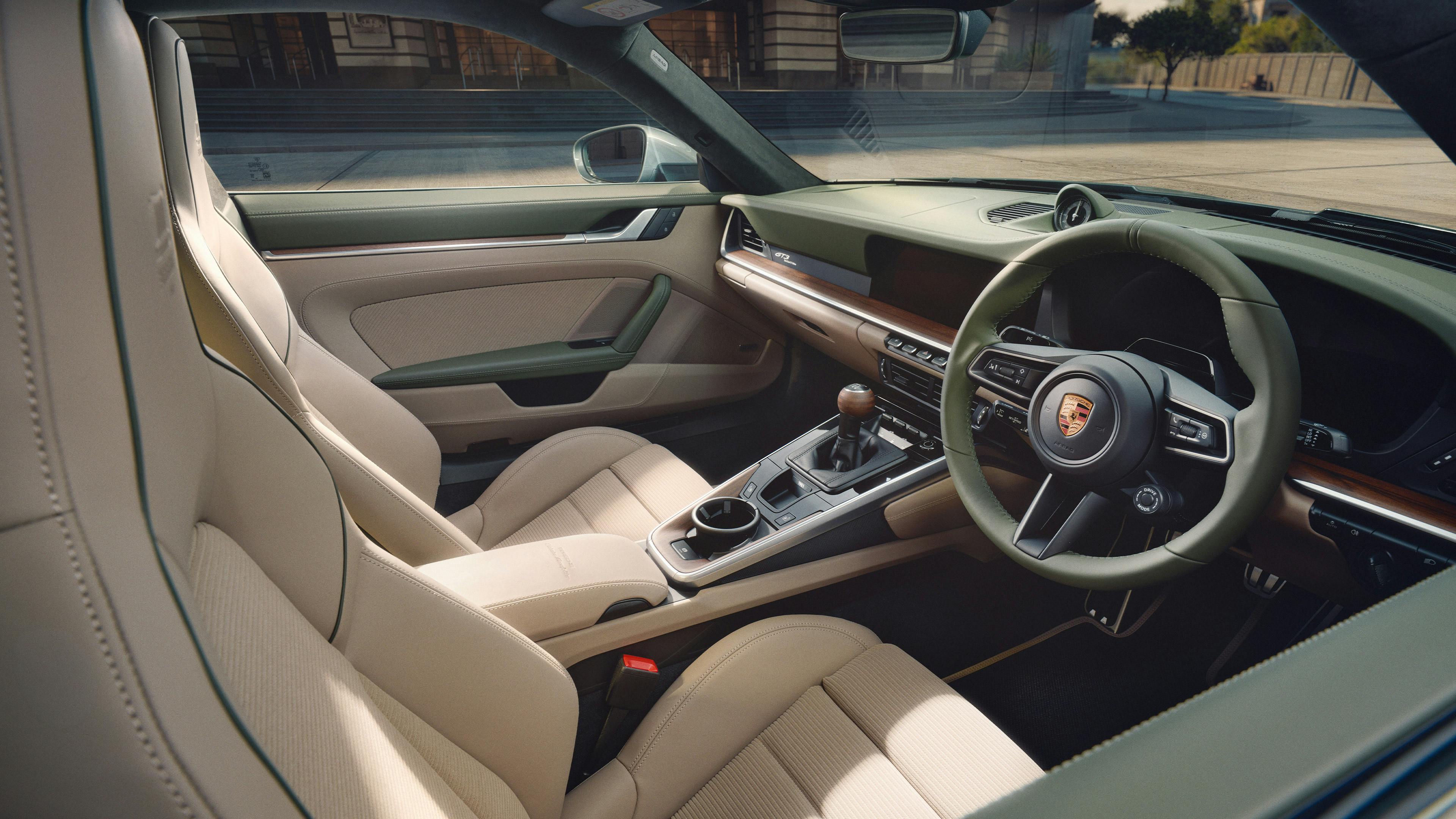 Interior of the Earls Court 51 Edition 911, featuring cream leather upholstery, a manual gear lever, and the Porsche-crest steering wheel.​