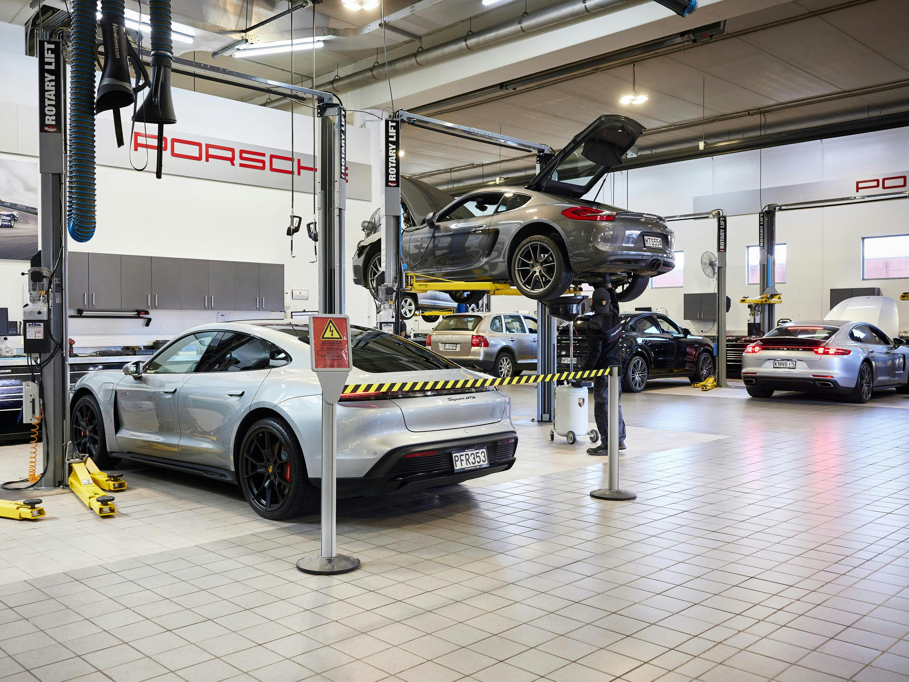 Porsche vehicles in workshop.