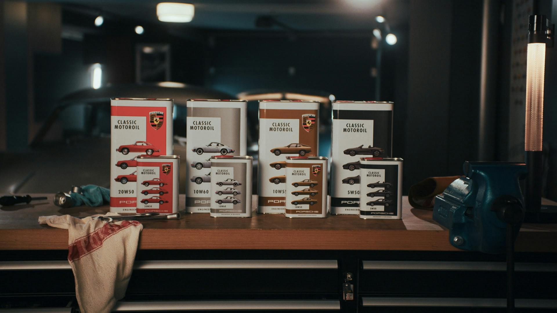 Packshot of four different variants of the Porsche Classic Motoroil in a garage.