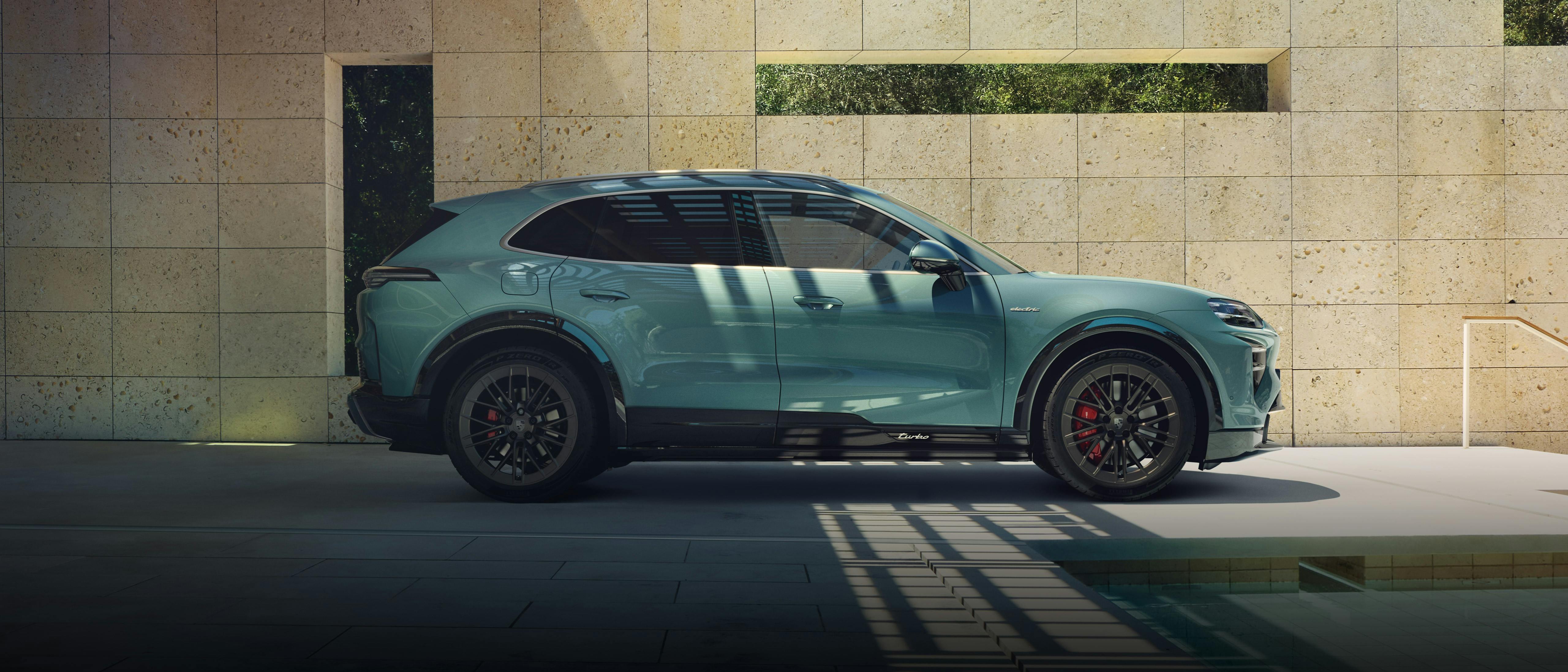 The Cayenne Turbo Electric SUV parked in a vibrant, modern environment, with a pool nearby.