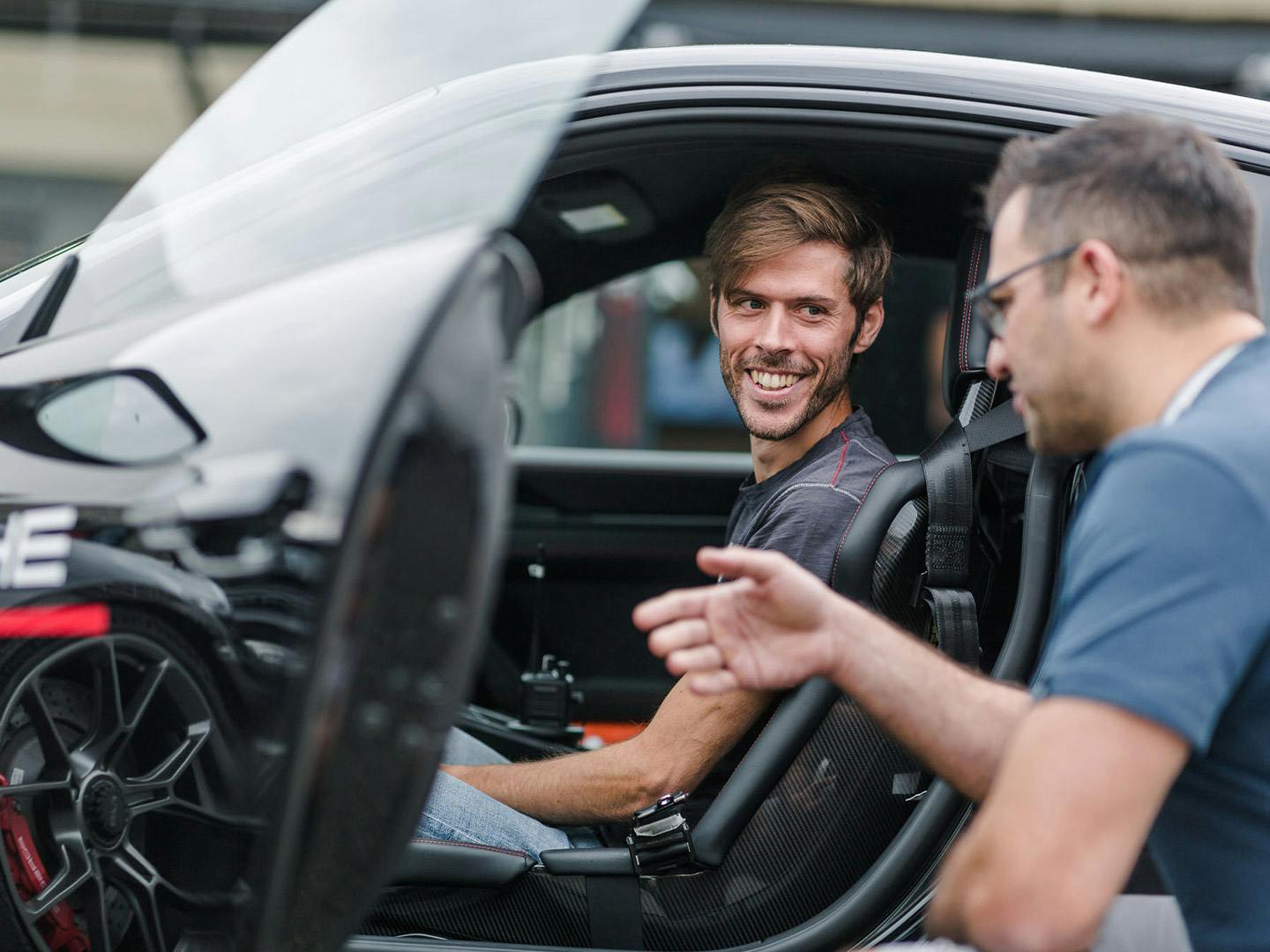 A Porsche fan smiling in the driver's seat.