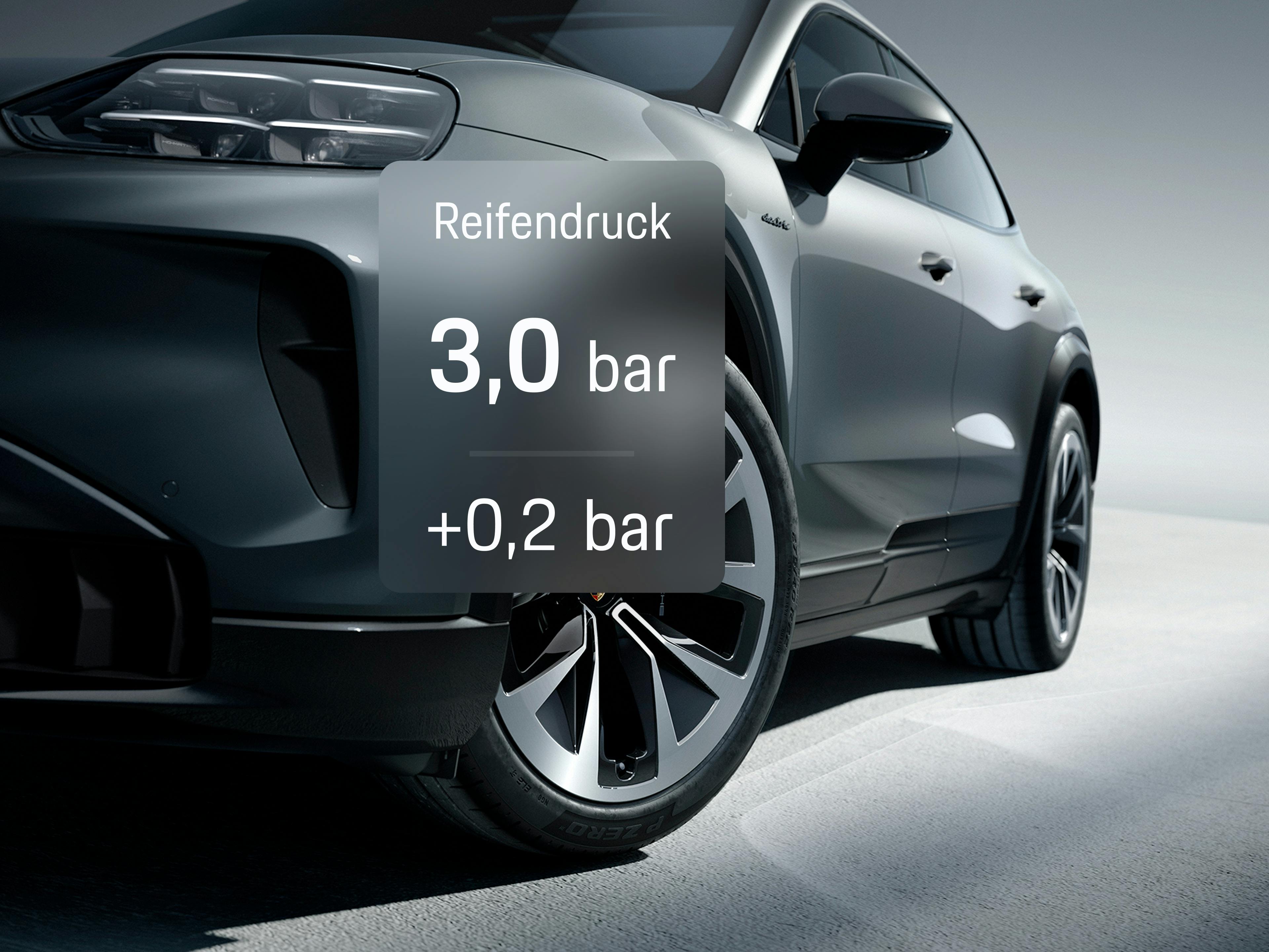 Nahaufnahme eines grauen Porsche-SUV mit Reifendruck-Overlay über dem Vorderrad als Teil einer App-Ansicht.
