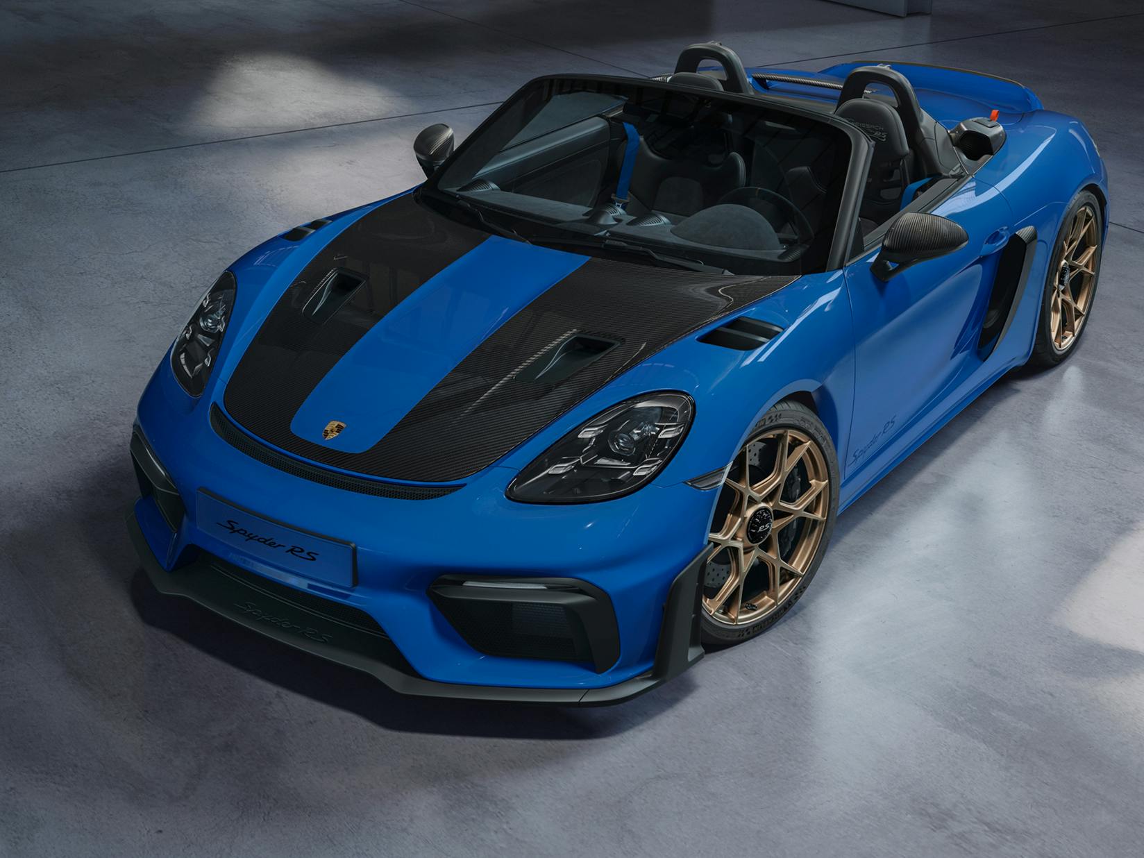 Porsche Exclusive Manufaktur 718 Spyder RS. Front view with a focus on the bonnet in carbon-weave finish with partial painting.