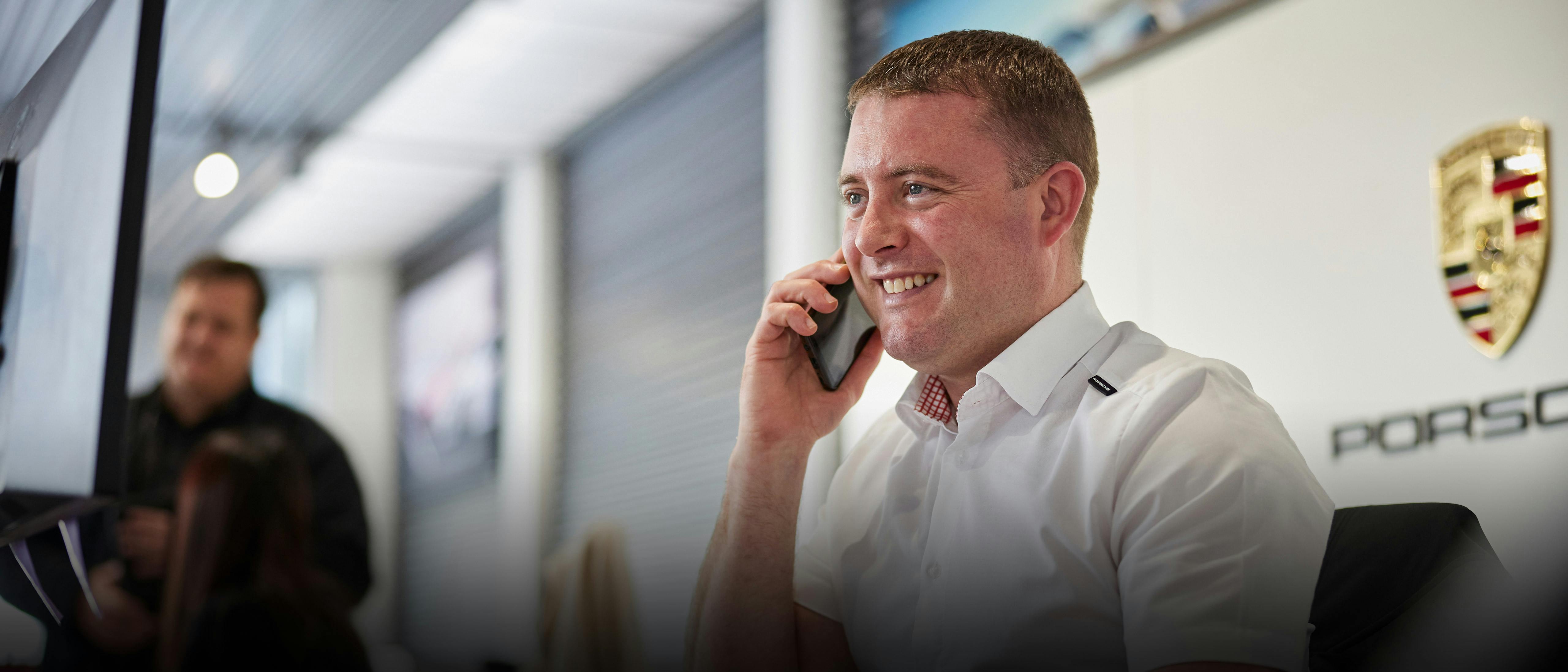 Porsche Service Consultant speaking with customer in an office