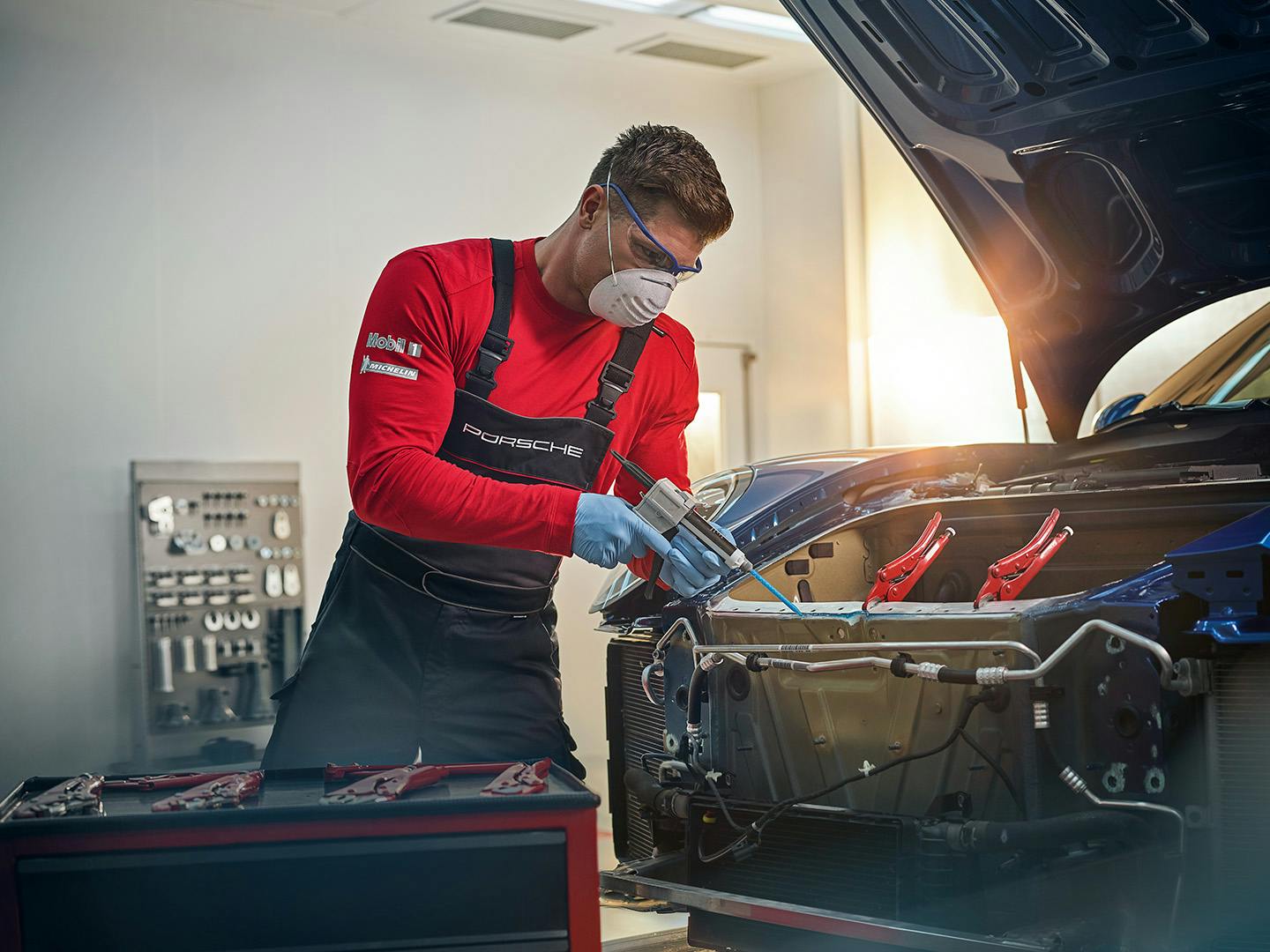 Empleado Porsche trabajando en un vehículo.