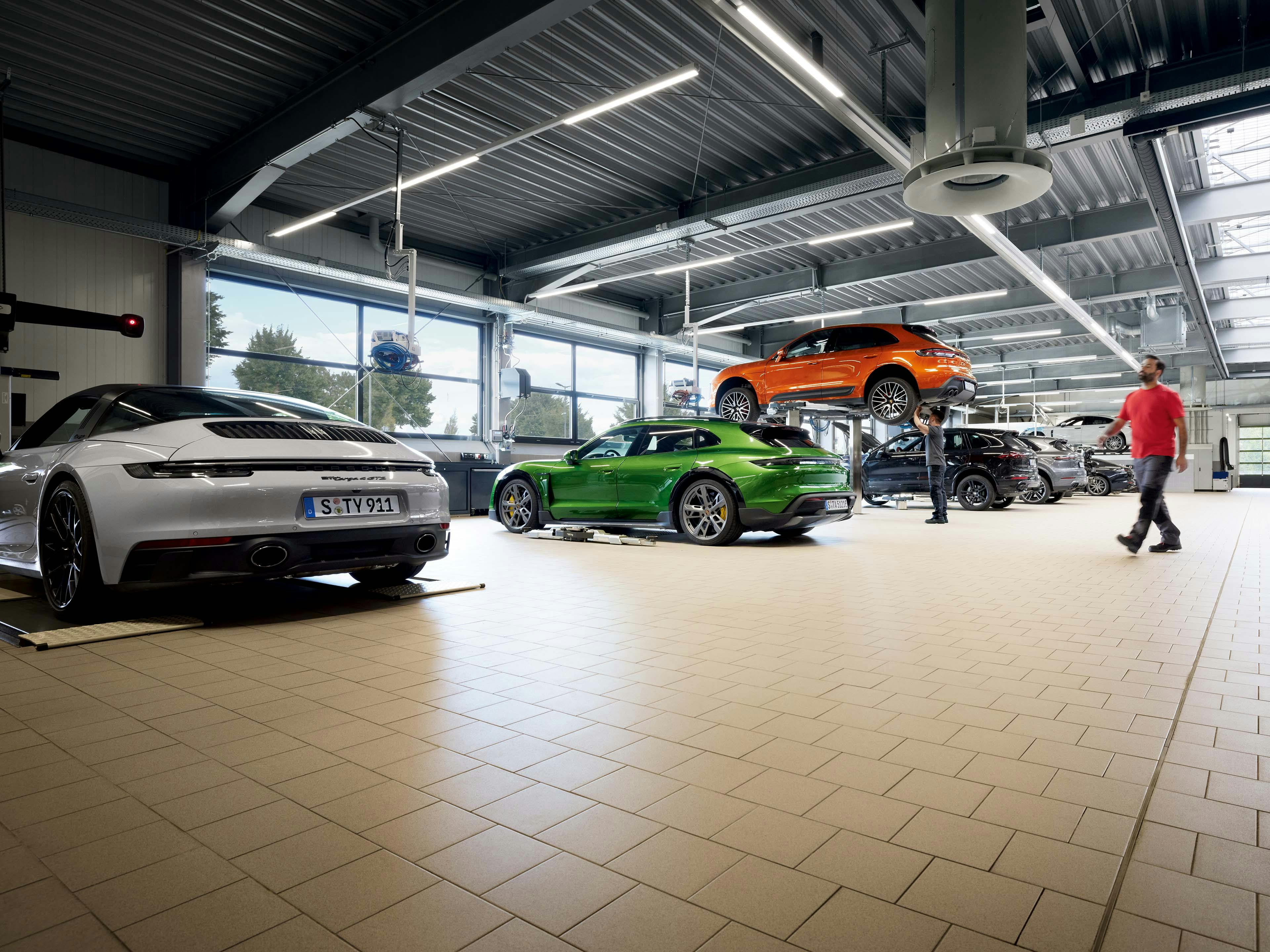 Porsche werkplaats met verschillende Porsche modellen.