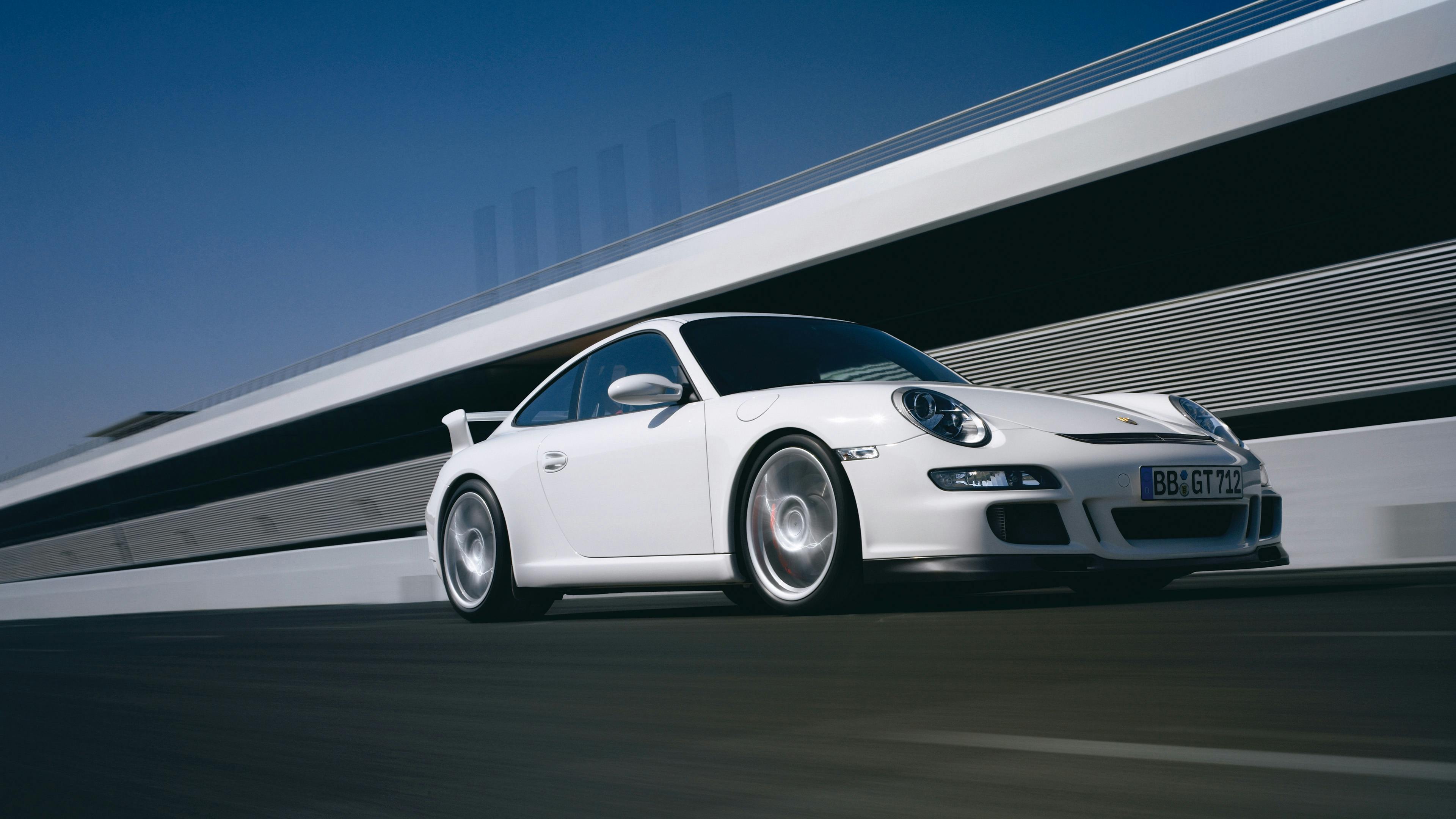 Driving white 911 GT3 type 997 on a race track.