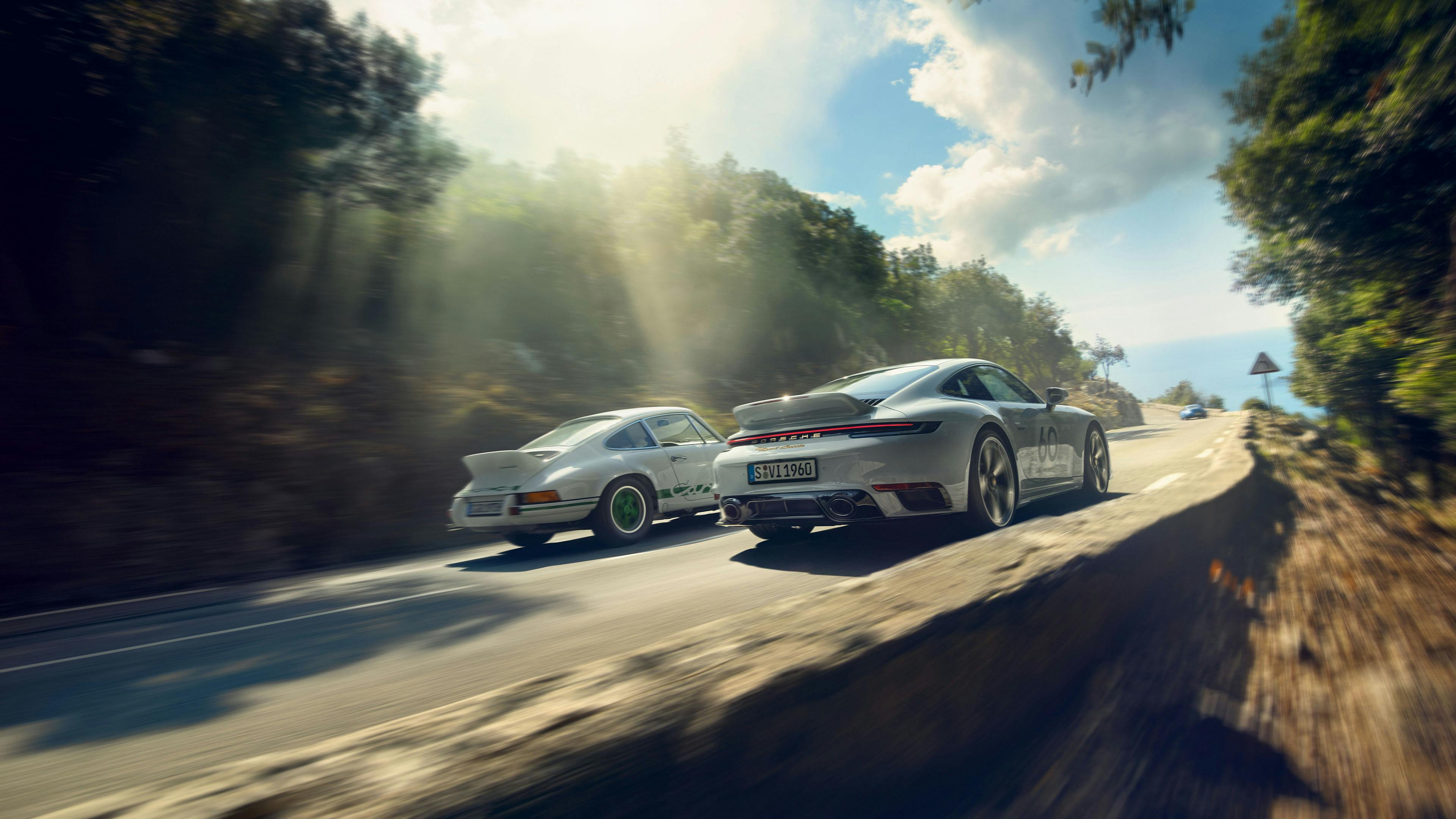 Porsche 911 Sport Classic samen met een Porsche 911 Carrera RS 2.7 rijden door de bergen.