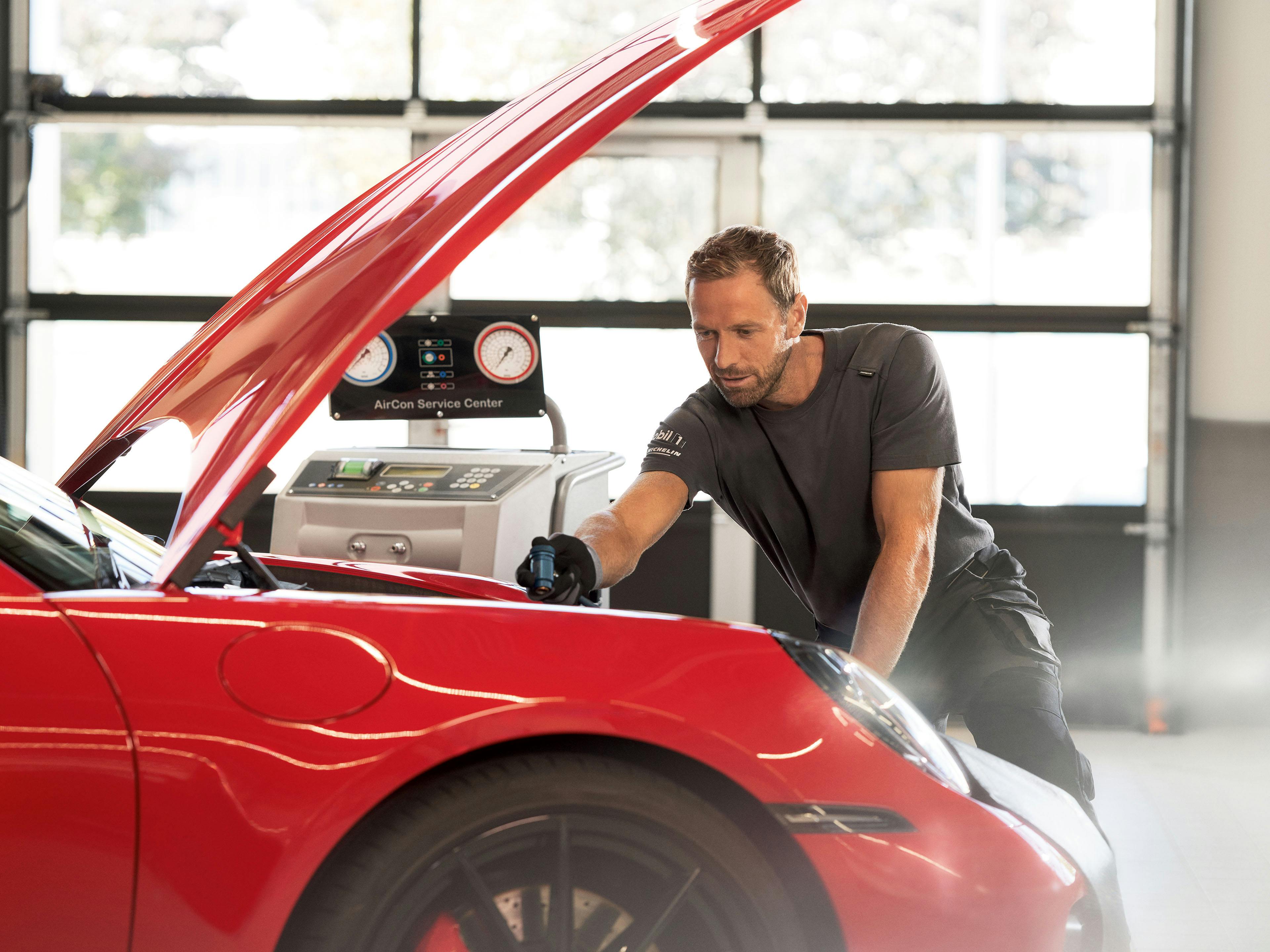 Een Porsche monteur checkt de airco van een Porsche in de werkplaats.