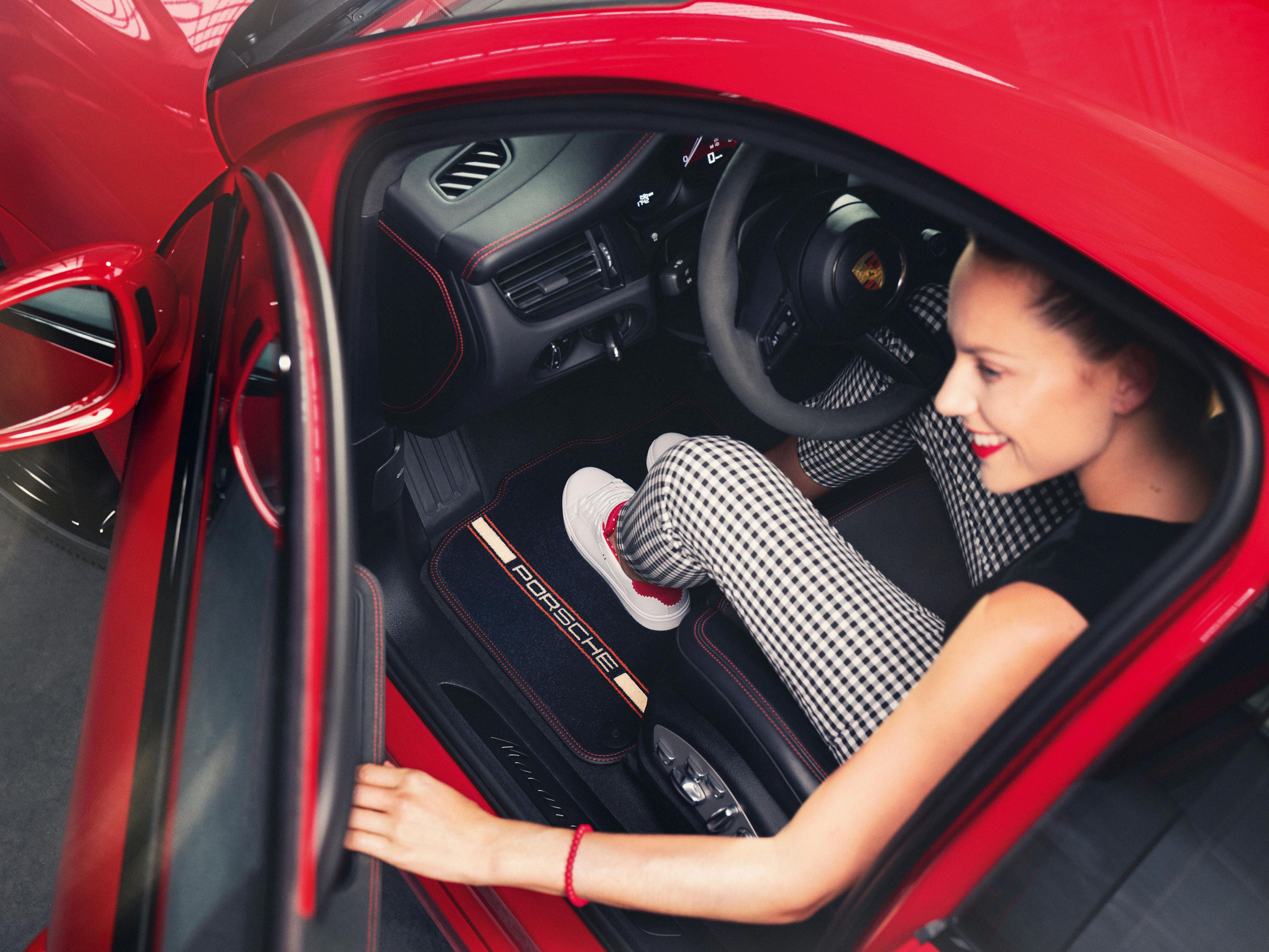 A woman stepping out of her red Porsche Macan.