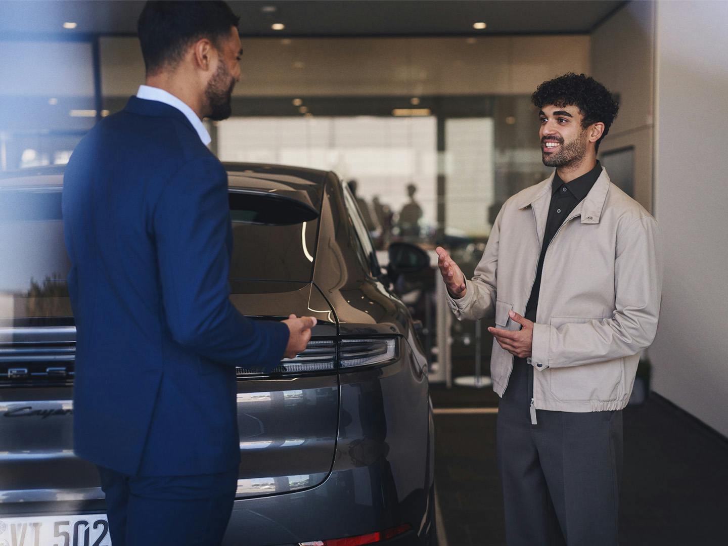 Verkoper van Porsche en klant in gesprek