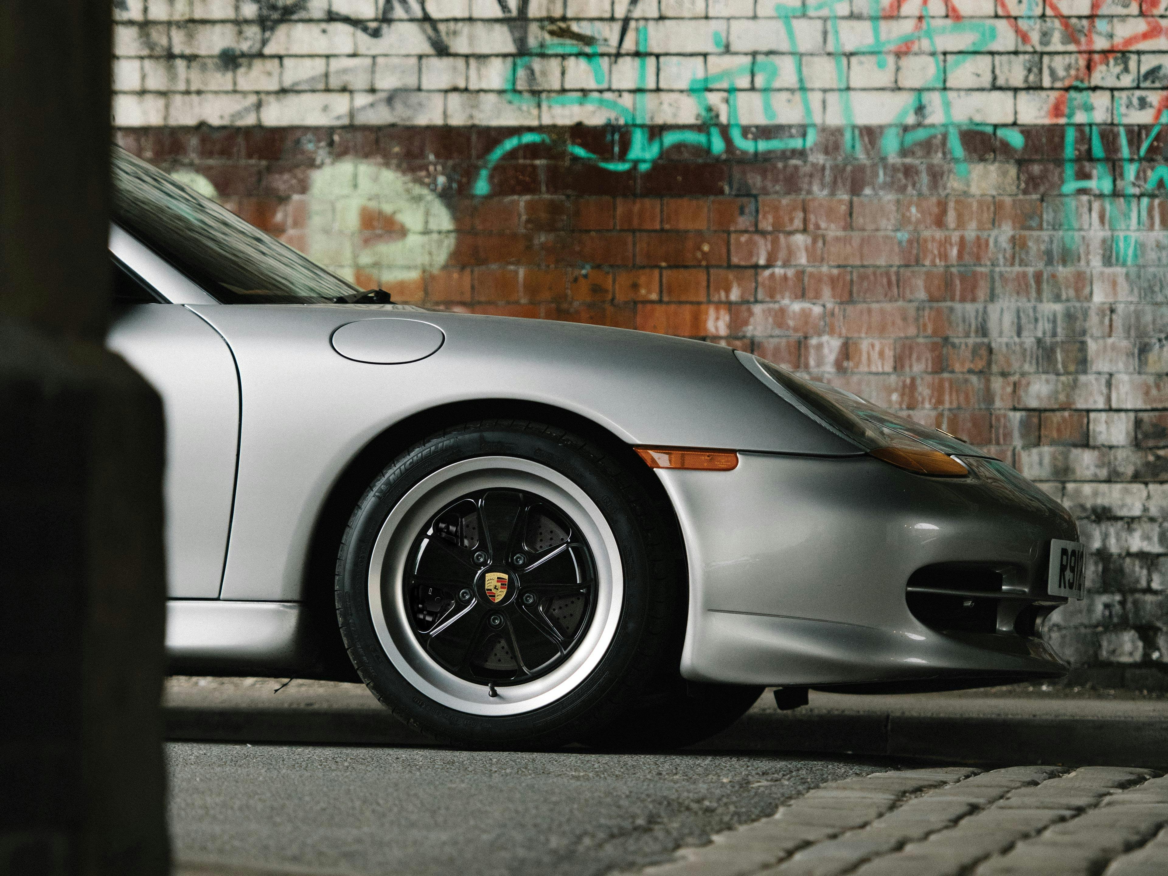 911 type 996 with black Fuchs rims in an urban setting.