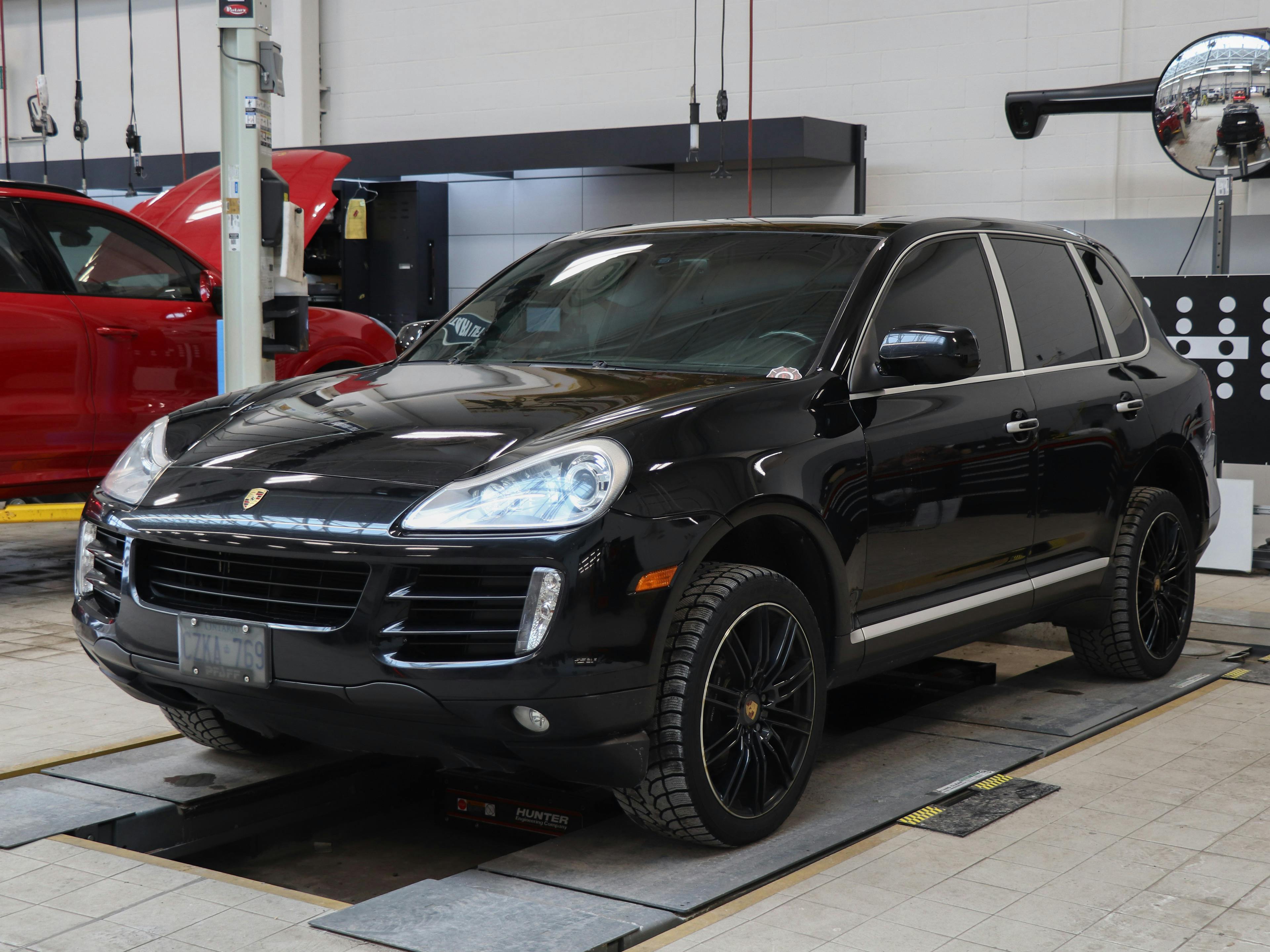 Markham – A black Porsche Cayenne positioned on a service platform in a workshop.