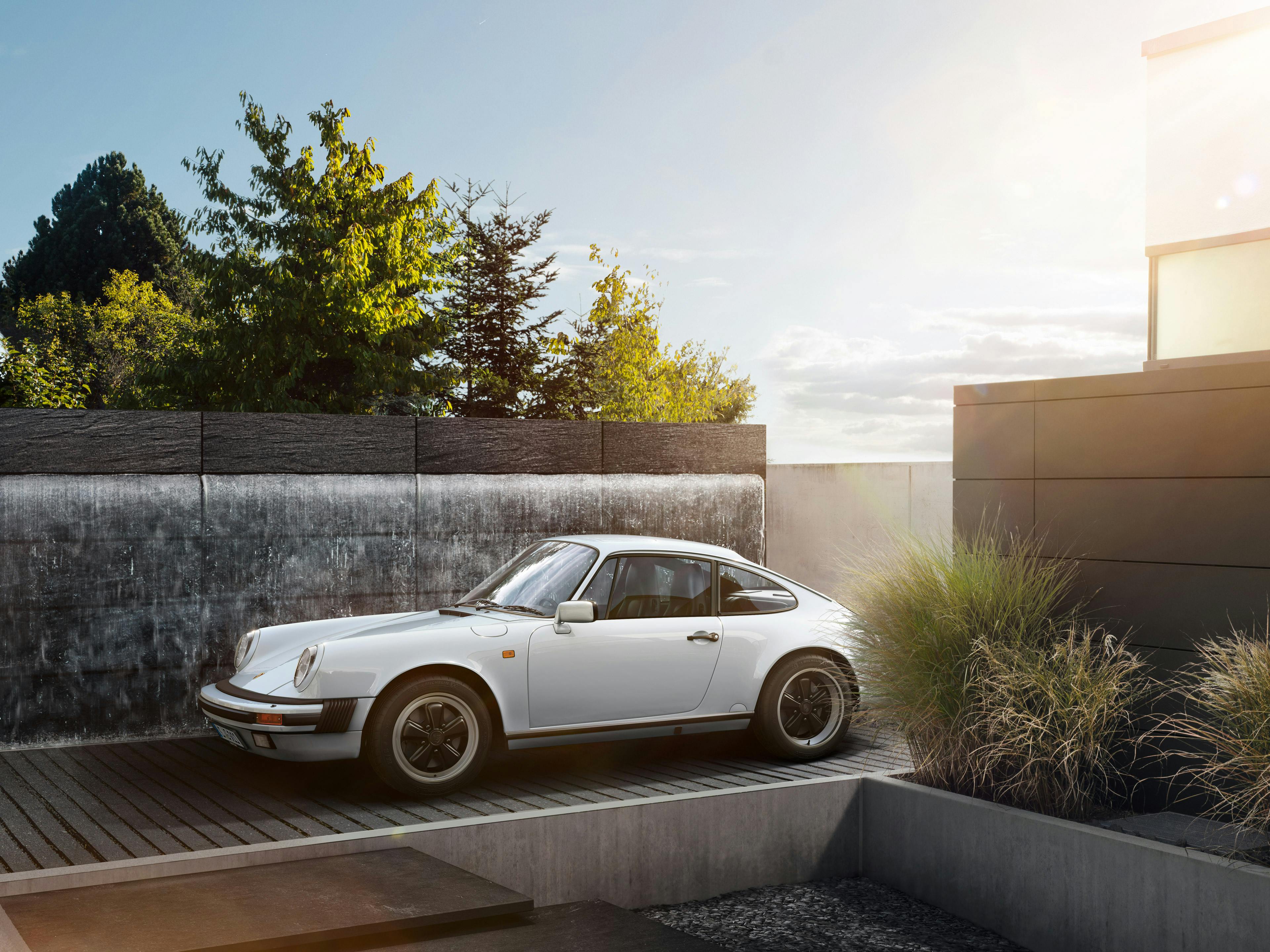 Porsche Oldtimer parkt vor einem Haus.
