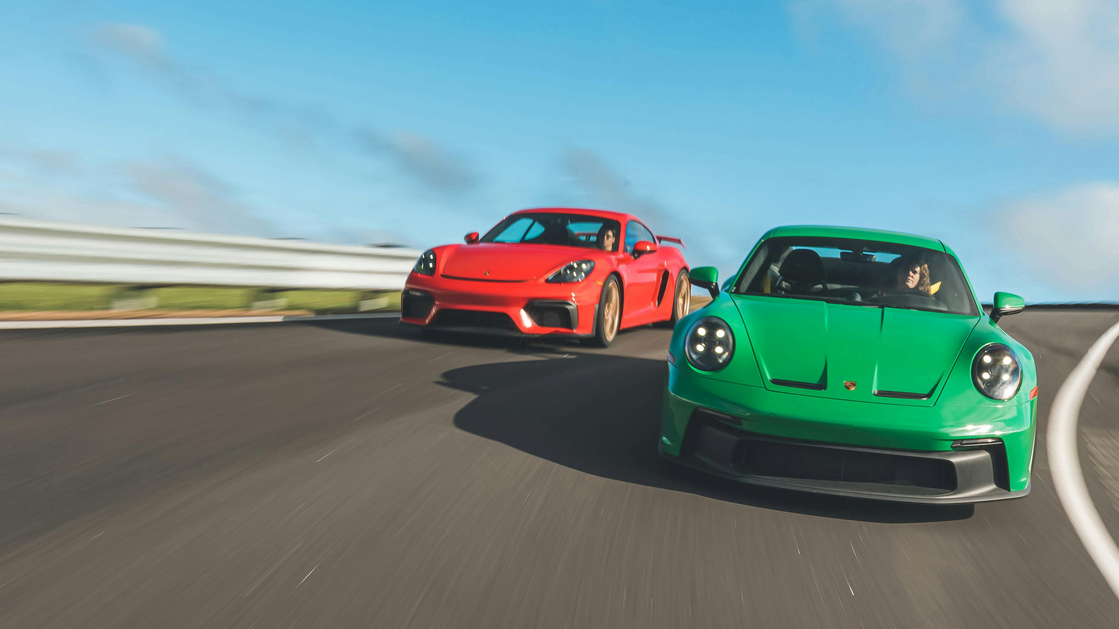 A red 718 Cayman GT4 and a green 911 GT3 driving side-by-side on a racetrack