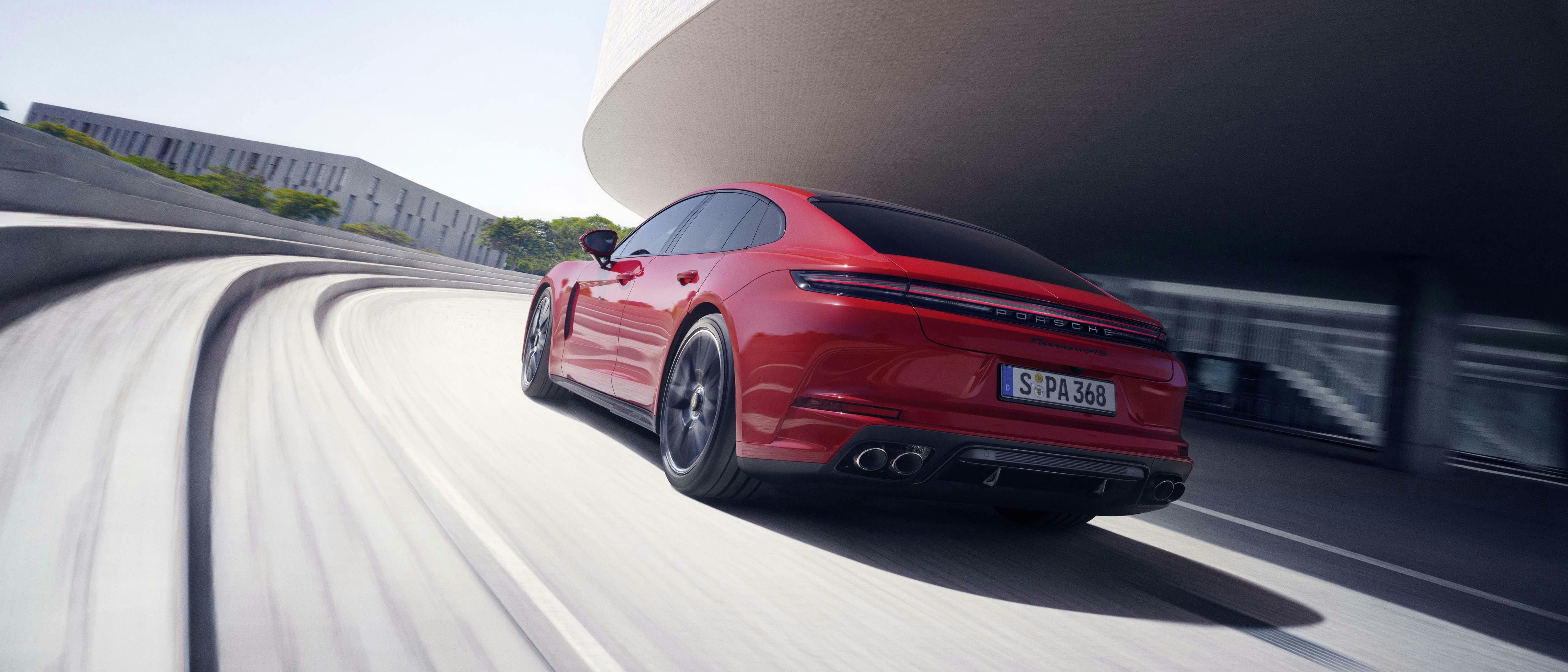 En röd Porsche Panamera GTS kör på en väg.