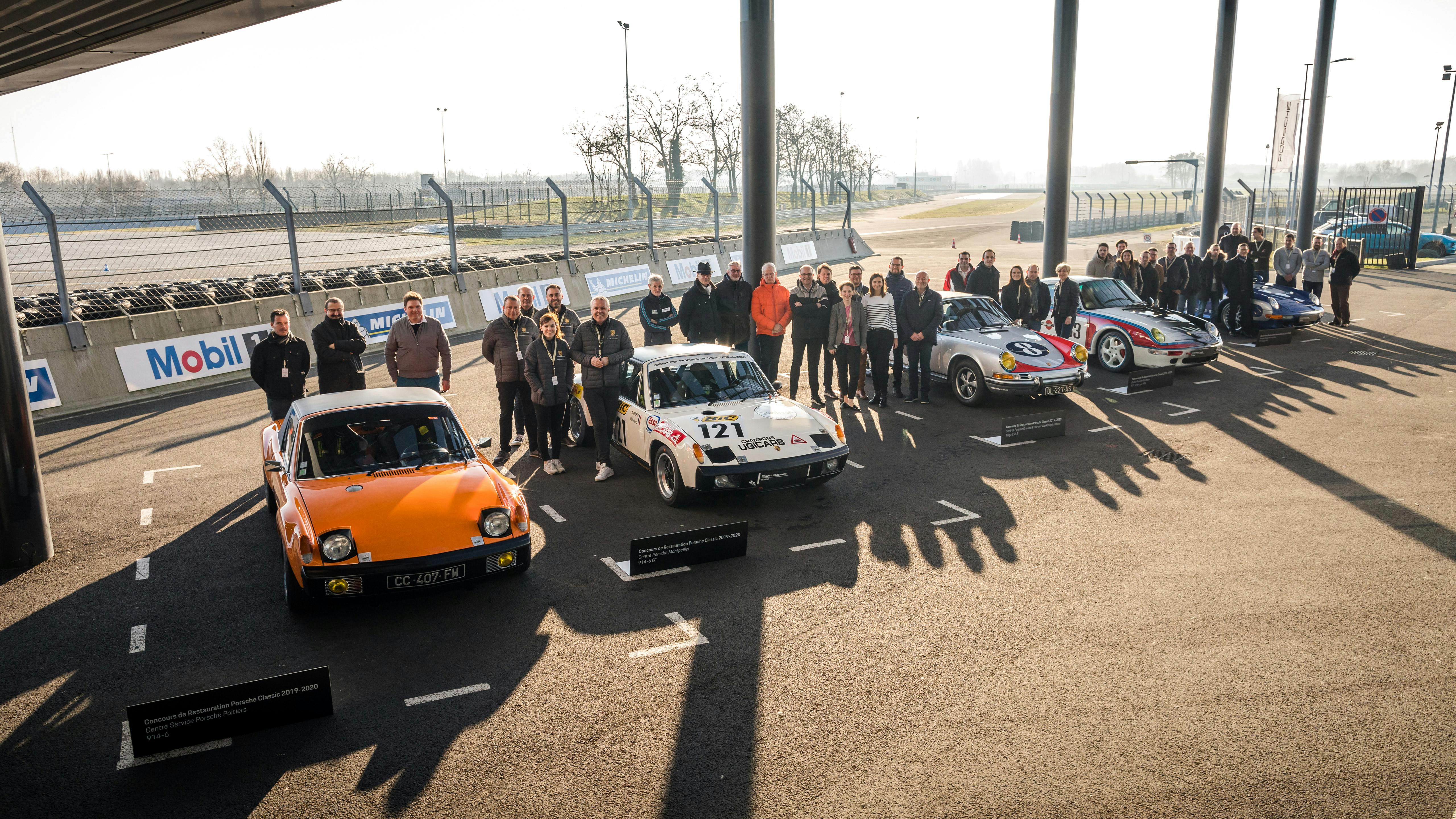 Les équipes participantes se tiennent derrière leurs véhicules au Porsche Experience Center Le Mans.