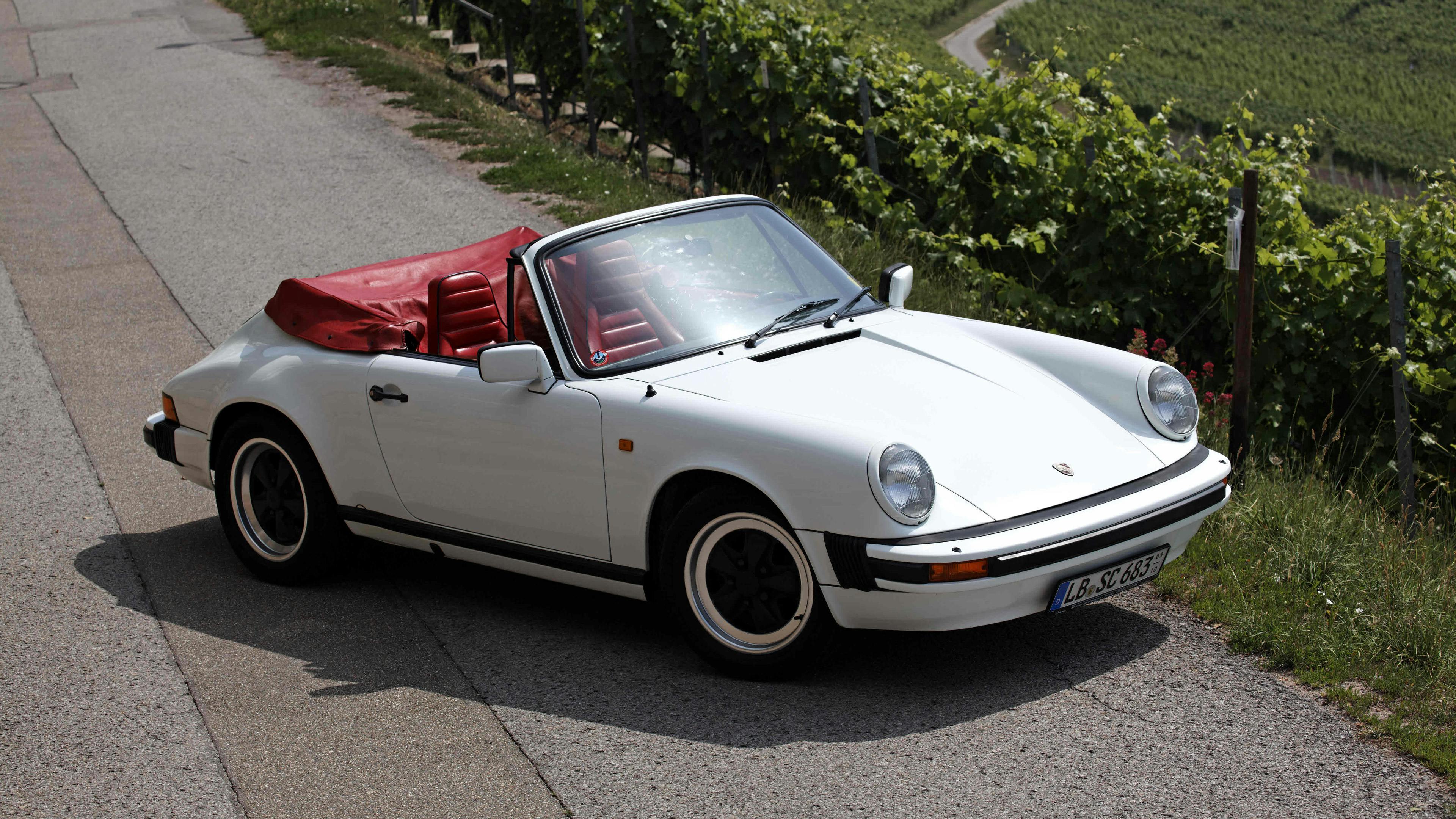 White Porsche 911 SC 3.0 Cabriolet (1983) with seats in Red synthetic leather.