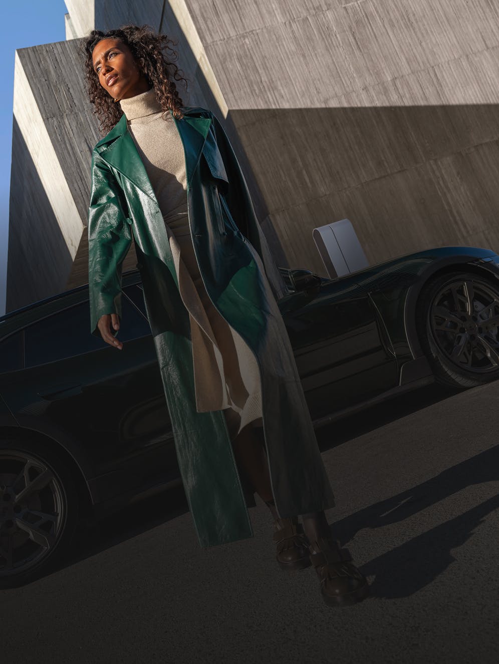 A woman walking past a Porsche Taycan Turbo Cross Turismo.