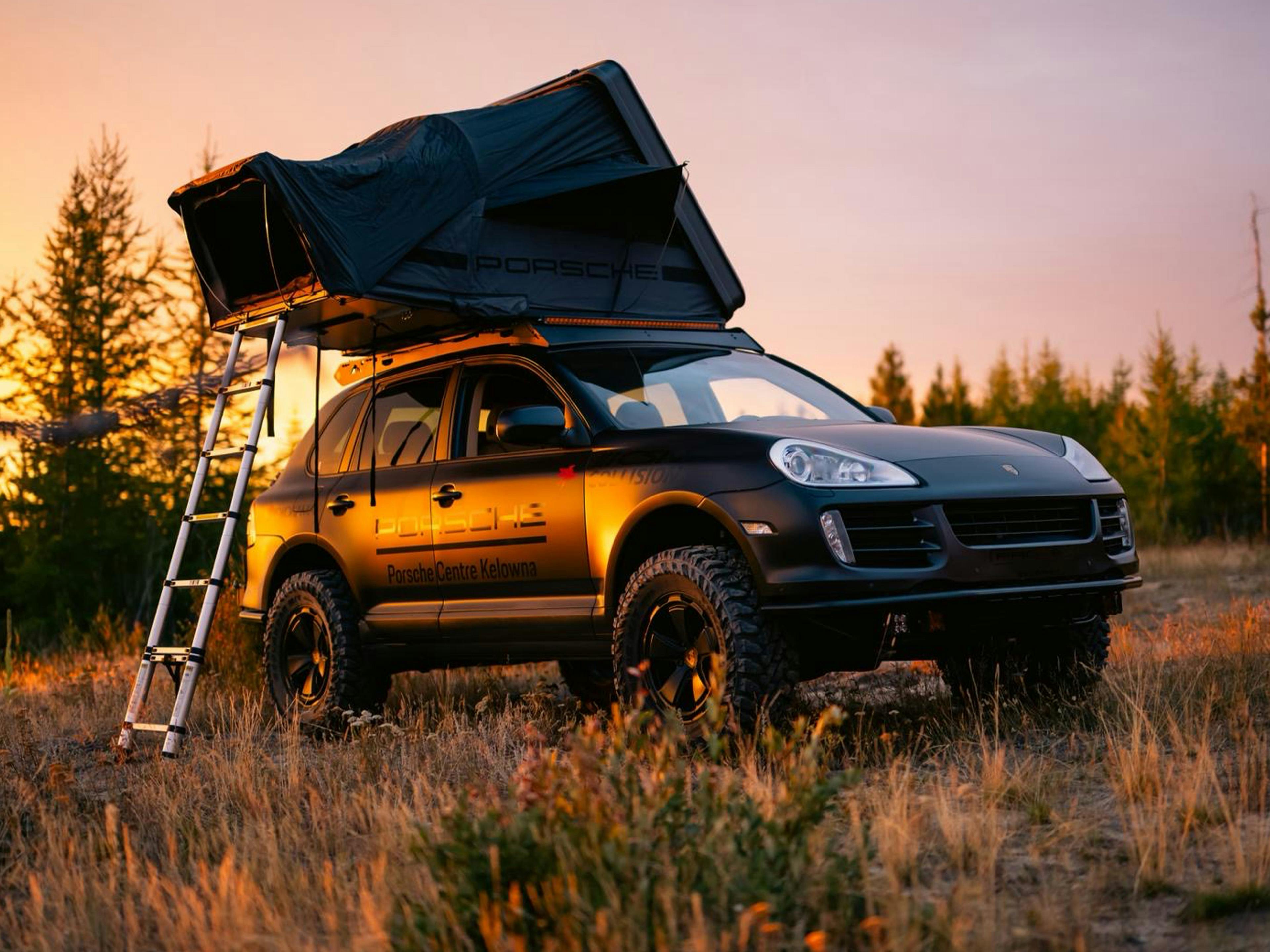 Kelowna – A black Porsche Cayenne on grass next to a road.