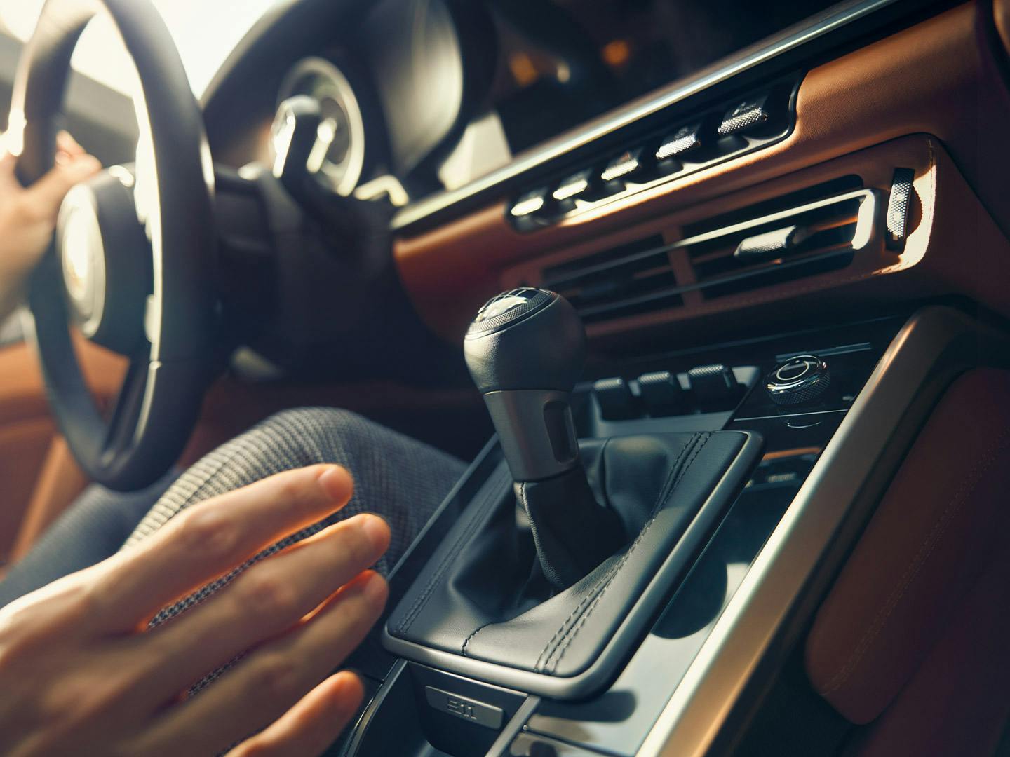 One hand reaches for the gearshift.
