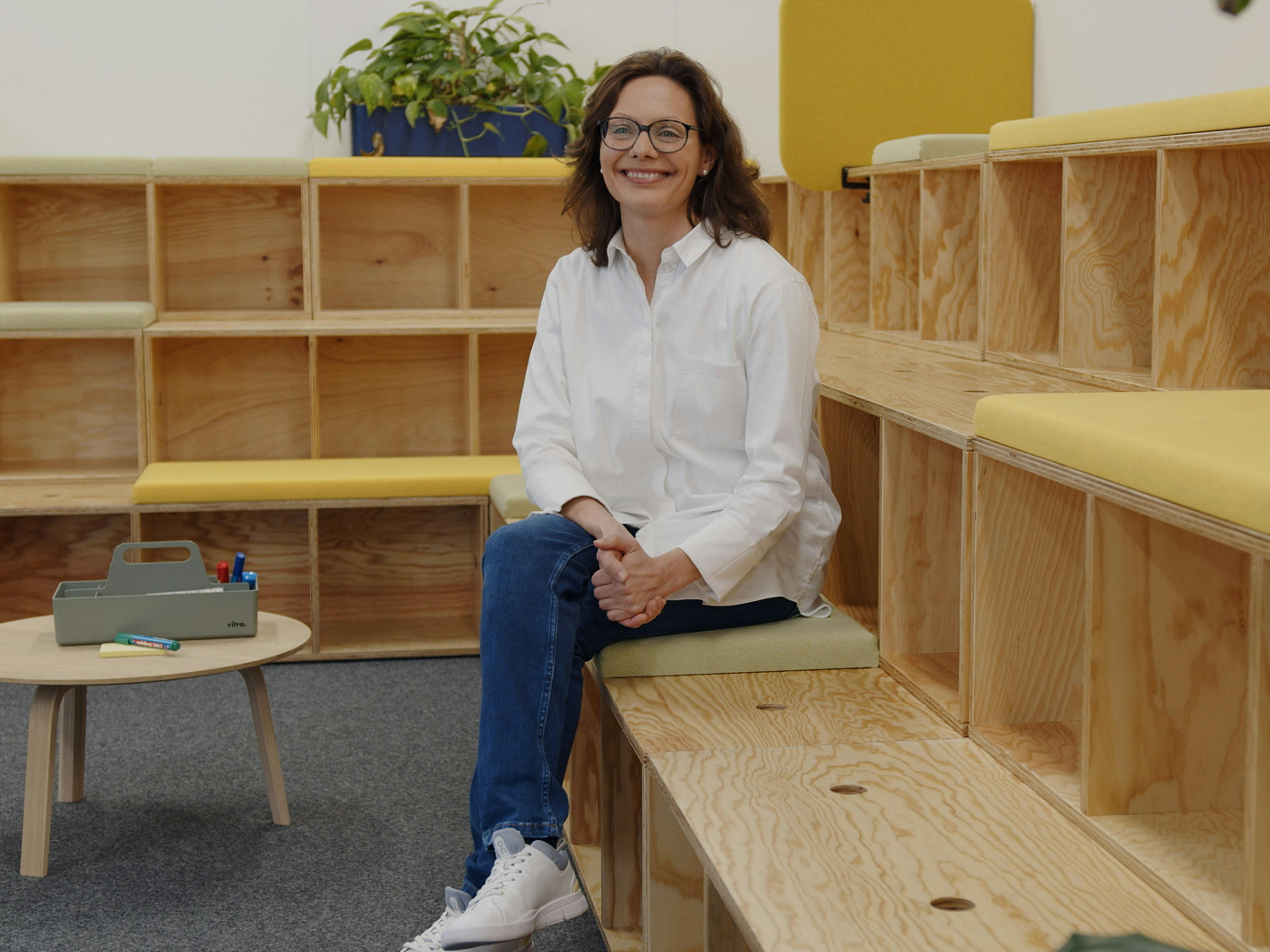 Die Porsche Mitarbeitern Judith sitzt in einer Sitzecke und berichtet von ihrem Job in der Entwicklung.