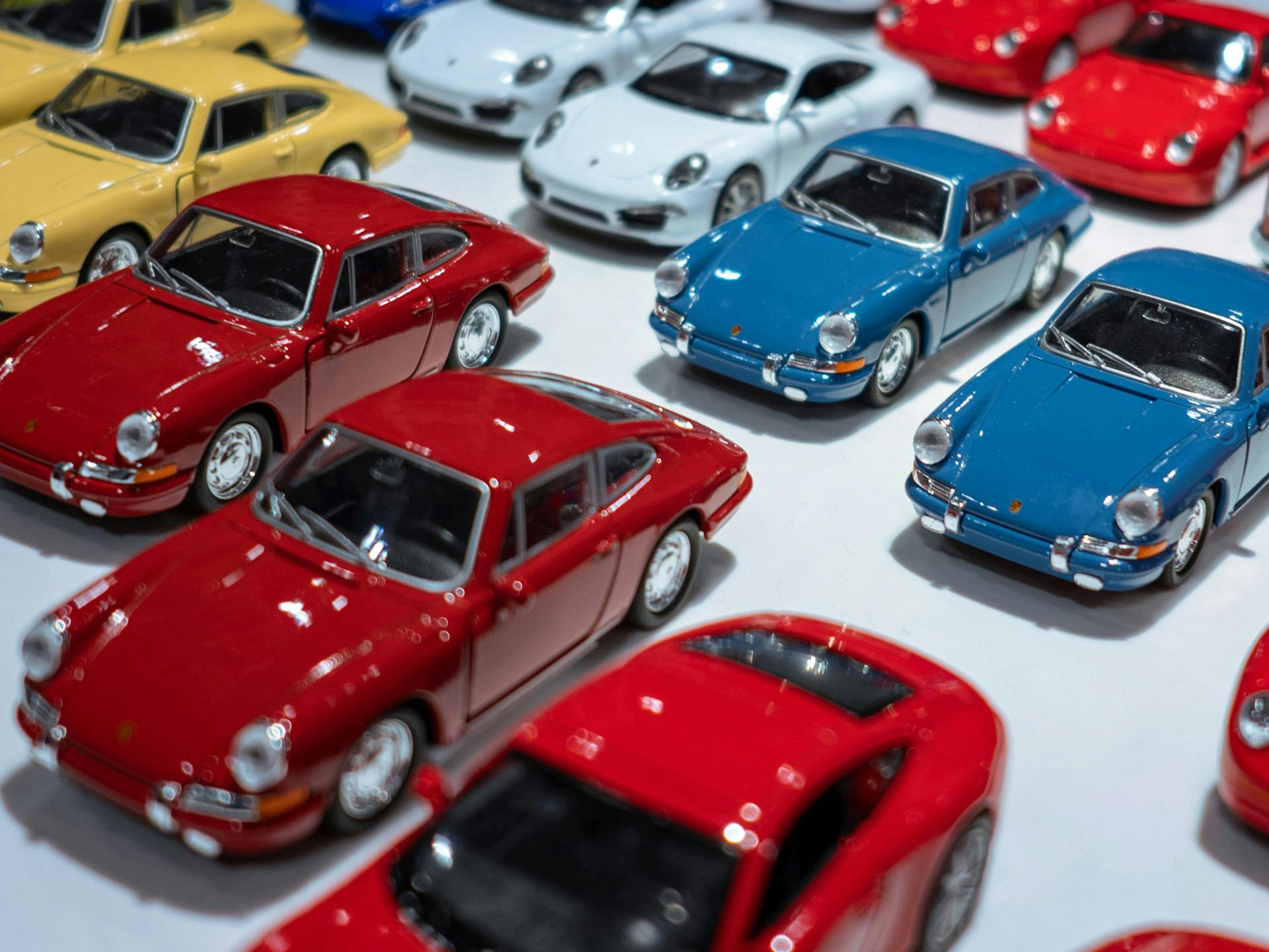 Verschiedenfarbige Porsche Modellfahrzeuge von schräg oben