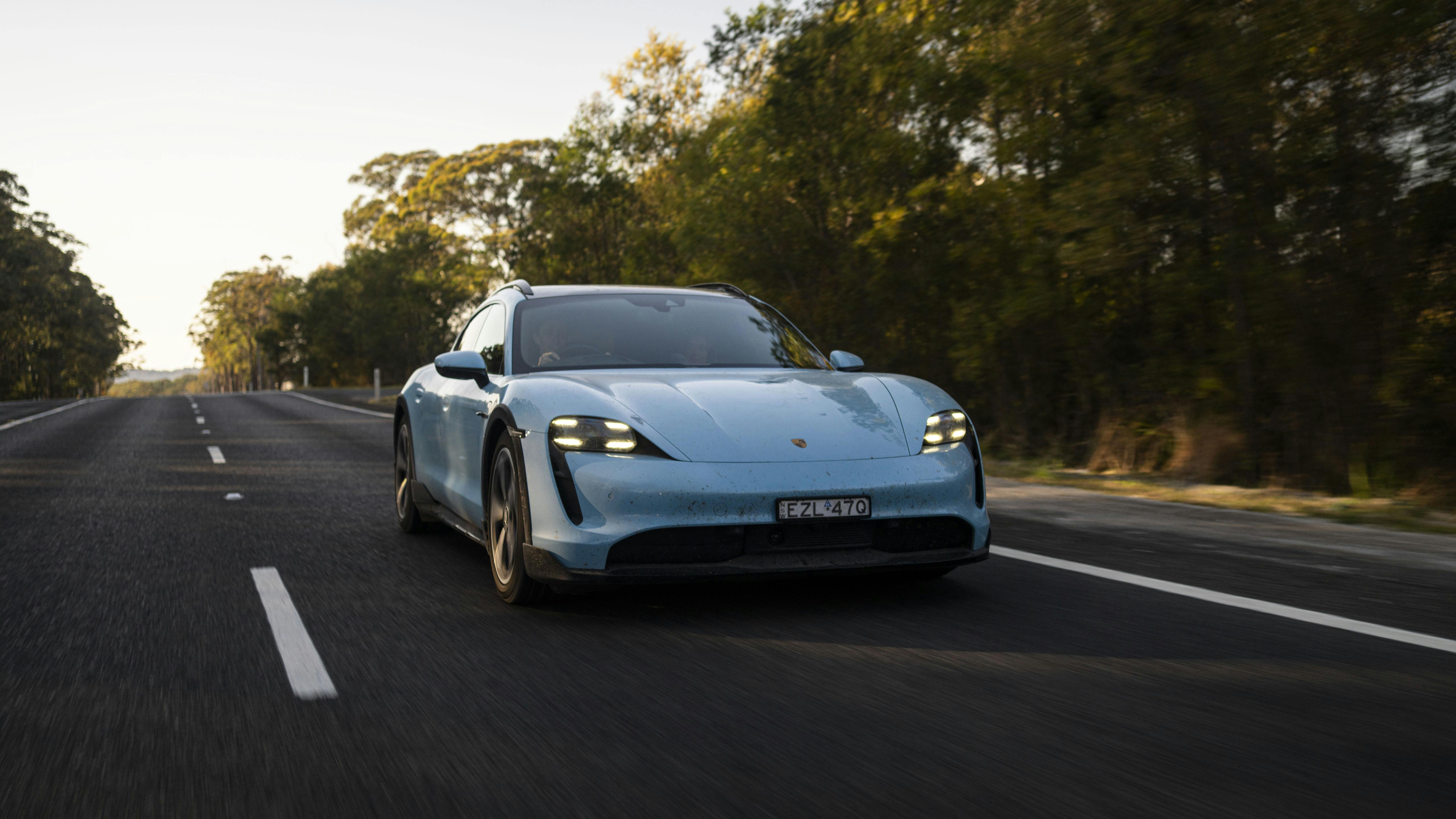 Front view of a Porsche Taycan driving on a forest road