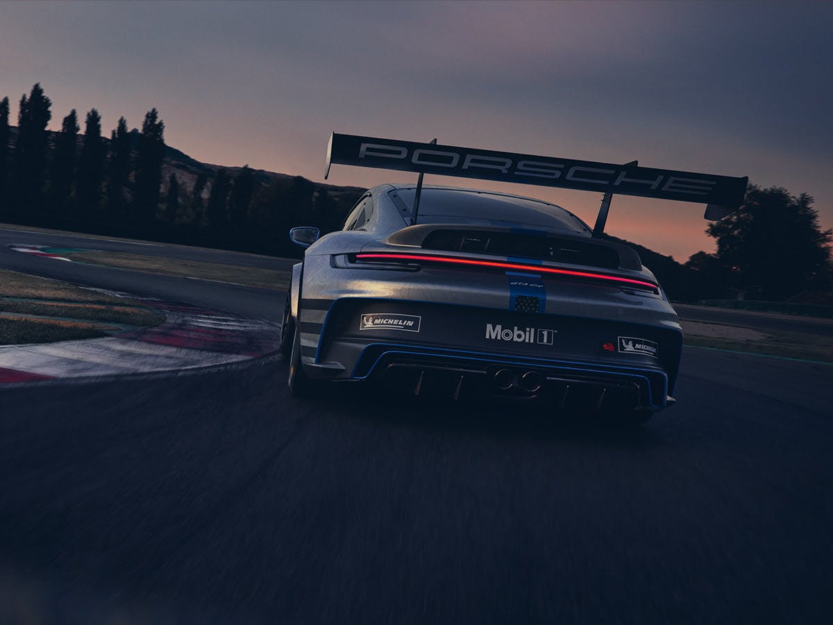 A Porsche 911 on a racetrack at sunset. The licence plate reads Mobil 1.