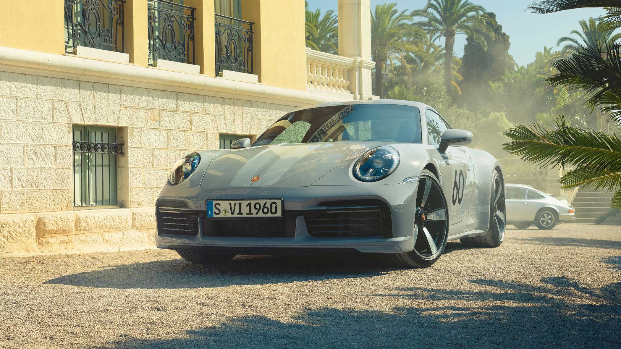 Porsche 911 Sport Classic in Sport Grey Metallic in front of a villa. Front view.