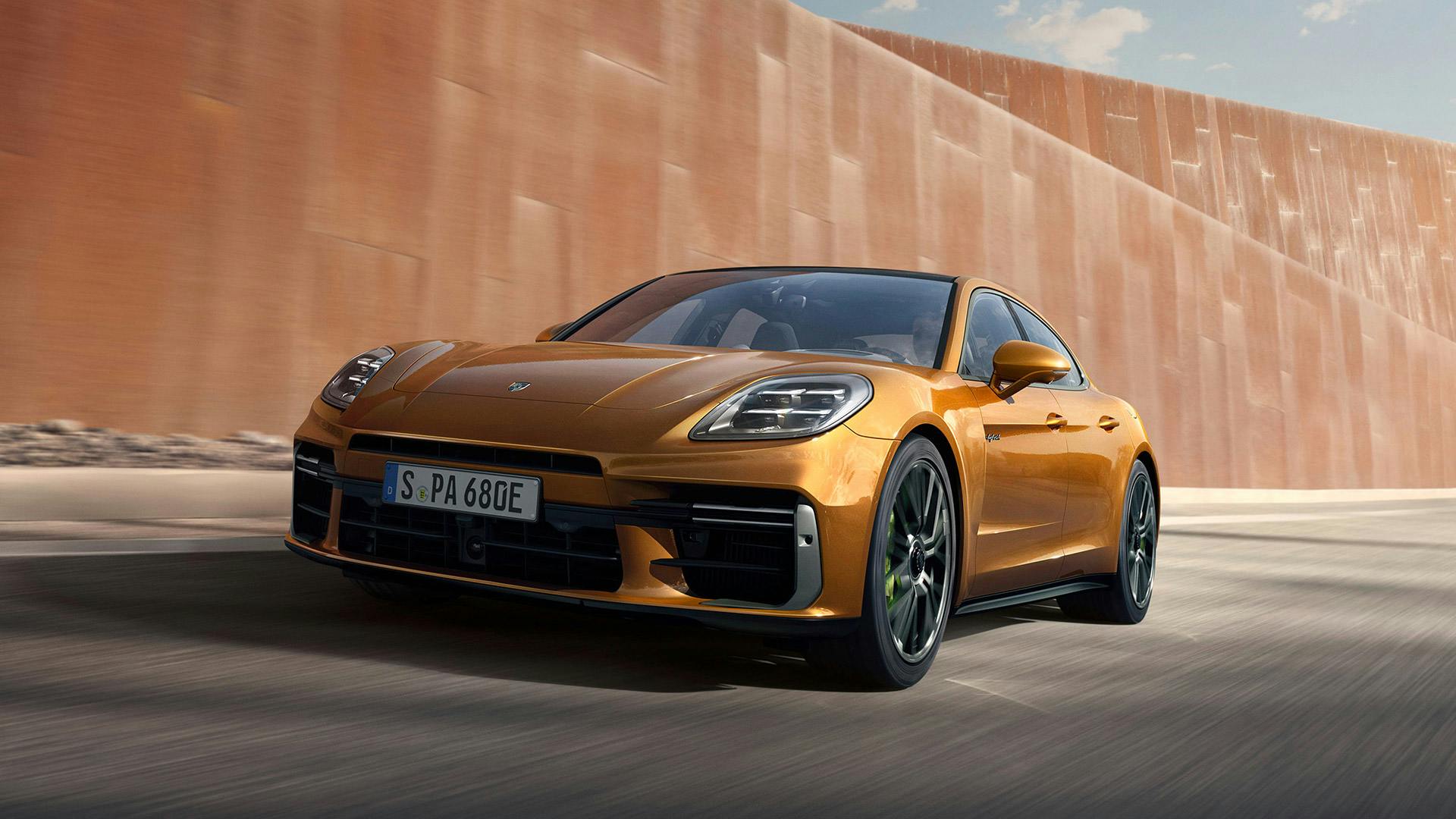 Porsche Macan Turbo in Ice Grey Metallic driving through a crossroads. Side view.