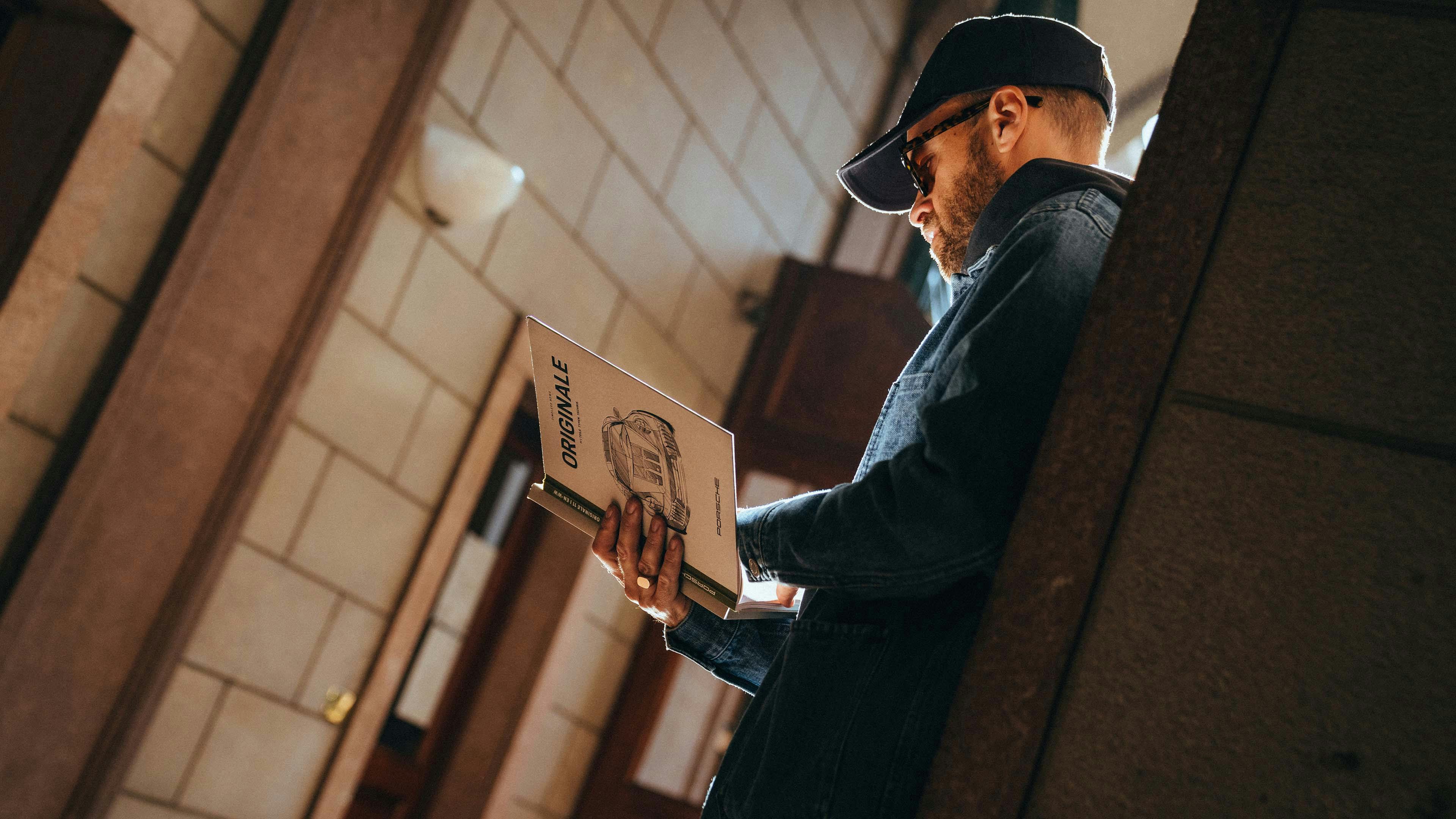 Andrea Vailetti stands in a hallway leaning against a stone wall and reads ORIGINALE 11.