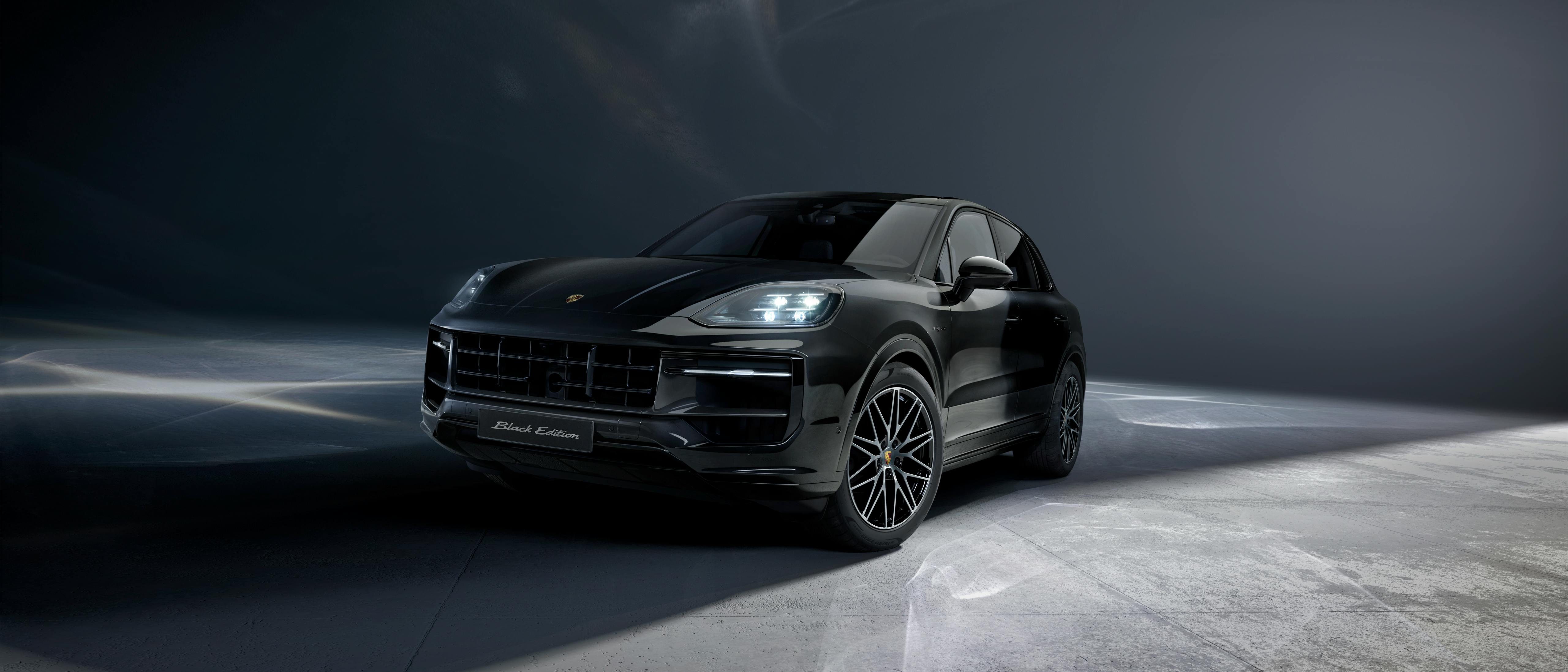Πρόσοψη της νέας Cayenne Black Edition εν στάσει σε στούντιο με σκουρόχρωμο φόντο.