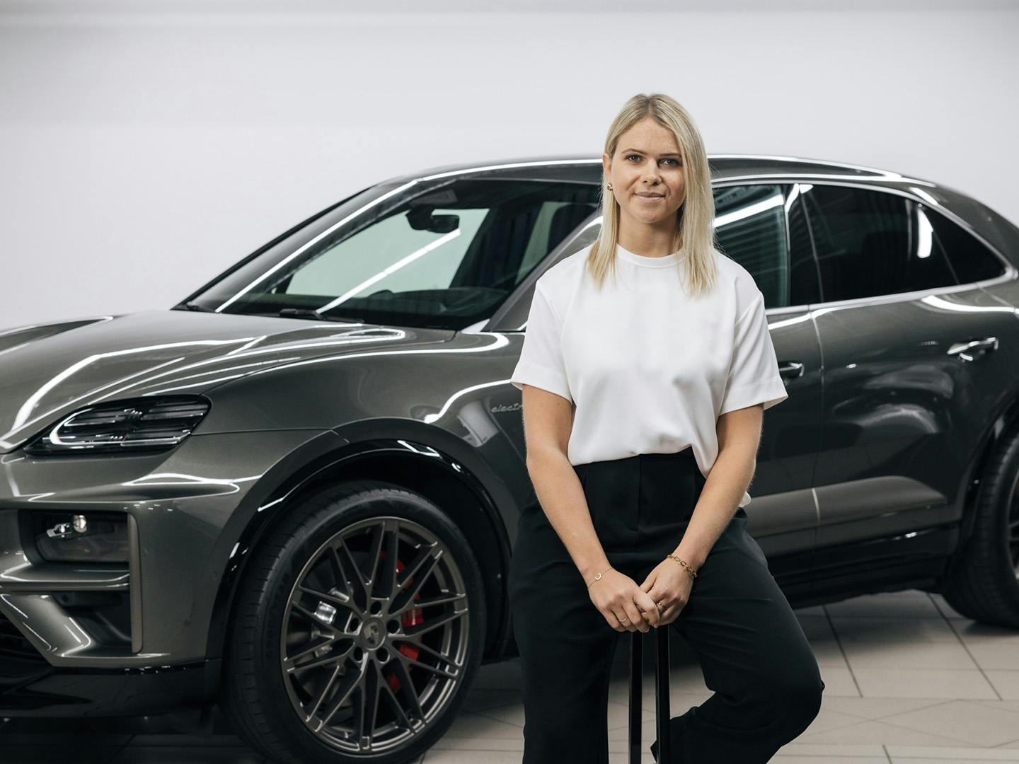 a woman is sitting infront of a car
