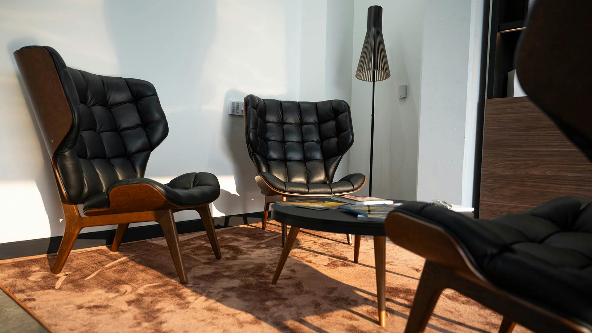Two lounge chairs and a coffee table in an upscale lounge. ​