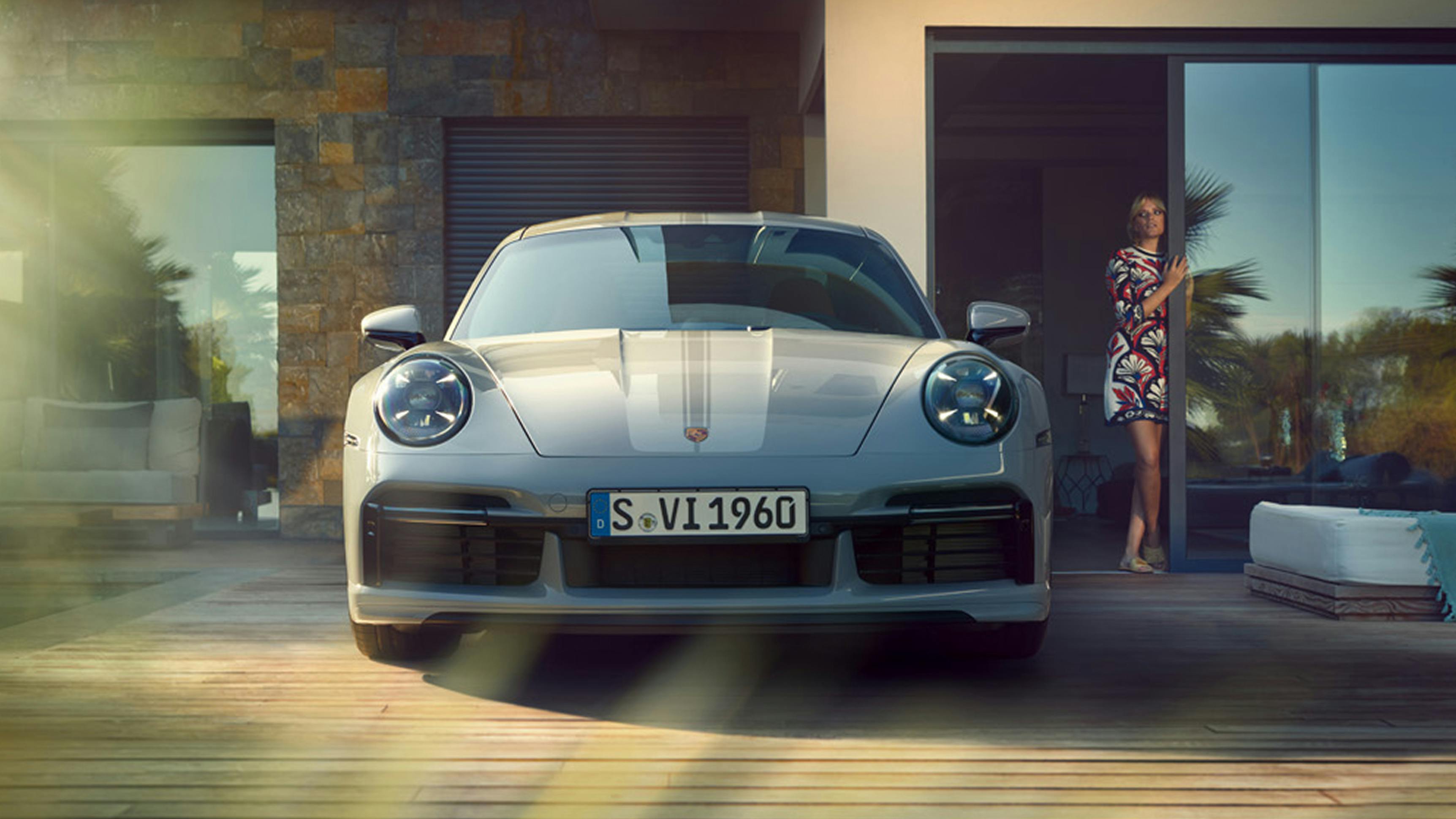 Porsche 911 Sport Classic in Sport Grey Metallic in front of a villa. Front view.