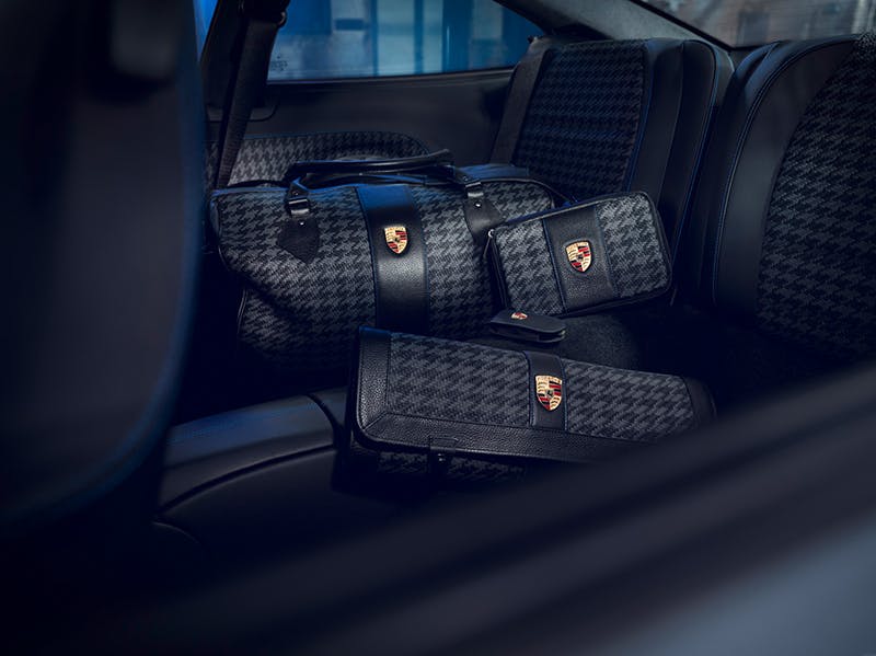 Accessories on the back seat: three different Porsche bags with Pepita pattern.
