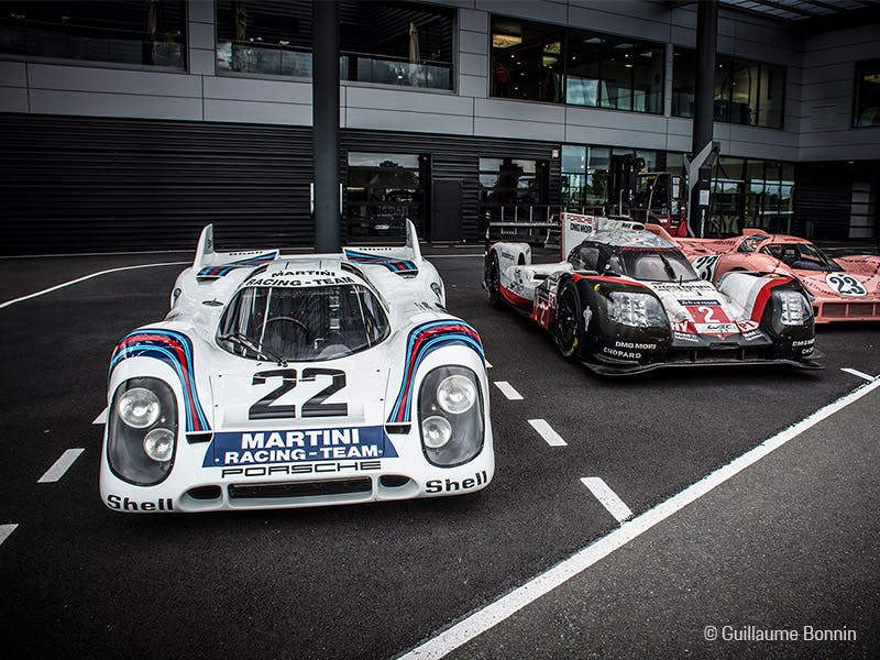 Blauer Porsche Taycan bei Ausstellung unter blauen Leuchten