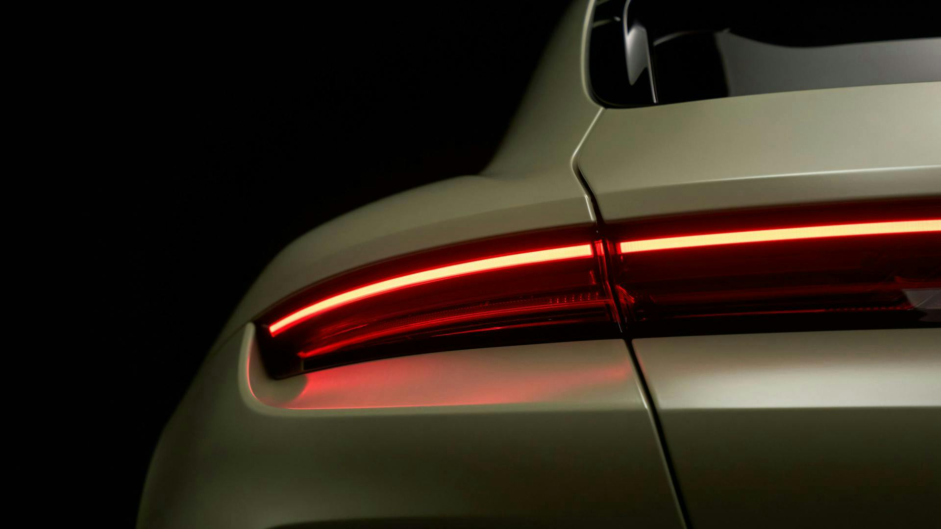 Rear three quarter detail of the Taycan Turbo S Soho House One with the illuminated red tail light bar and satin green bodywork.