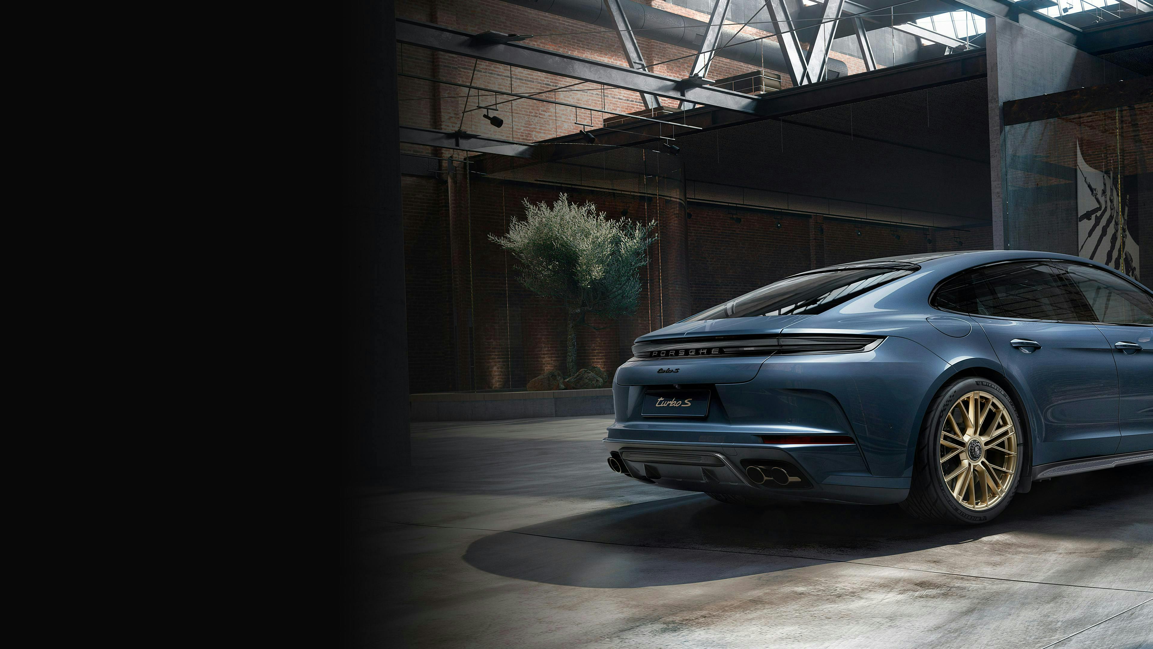 Panamera Turbo S E-Hybrid de Porsche Exclusive Manufaktur en color Azul Yate Metalizado, en un almacén. Vista lateral y trasera.