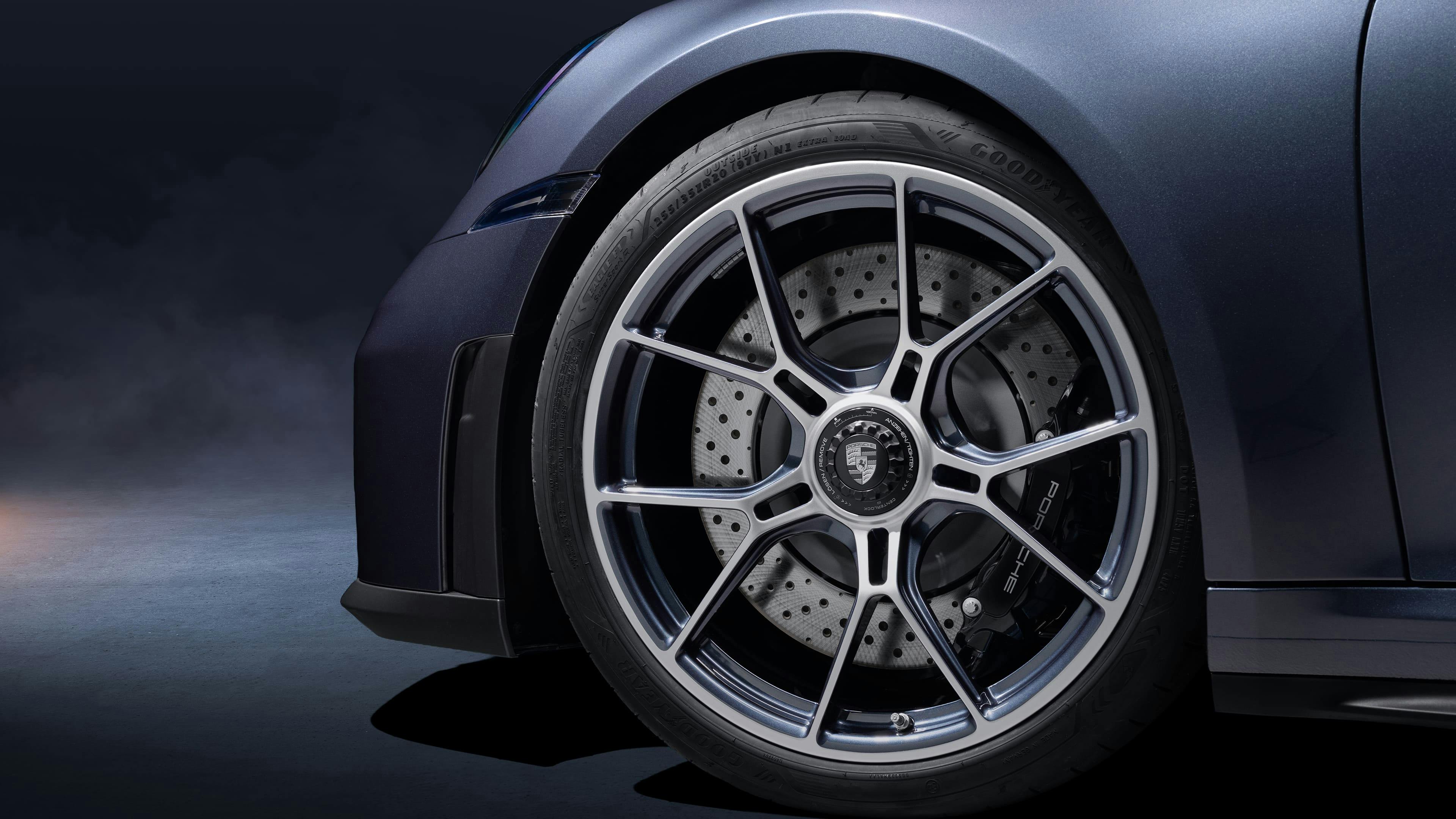 Close-up of a sports car wheel with multi-spoke alloy rim, ventilated brake disc and black brake caliper.