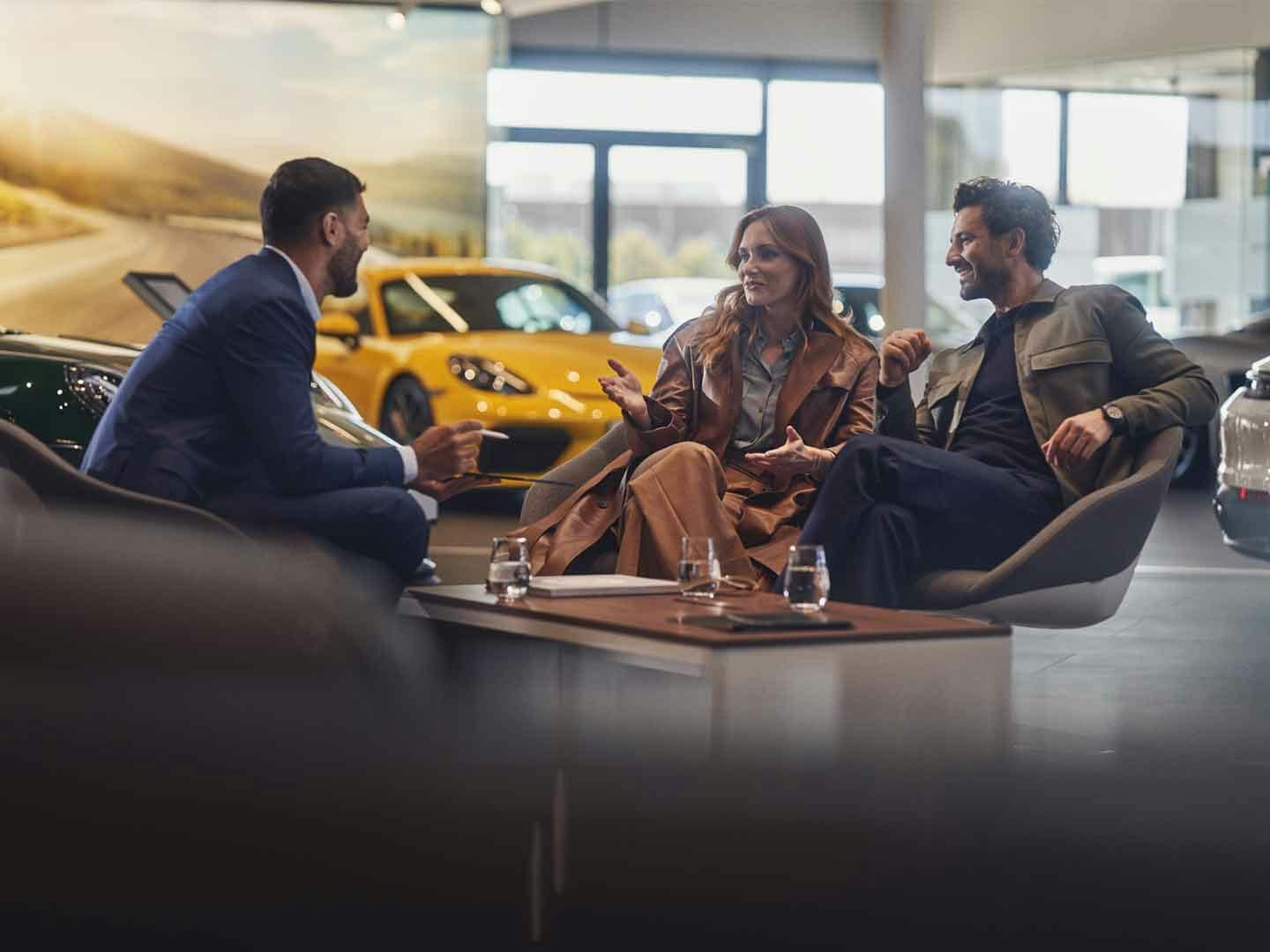 Två personer på rådgivning hos ett Porsche Center.