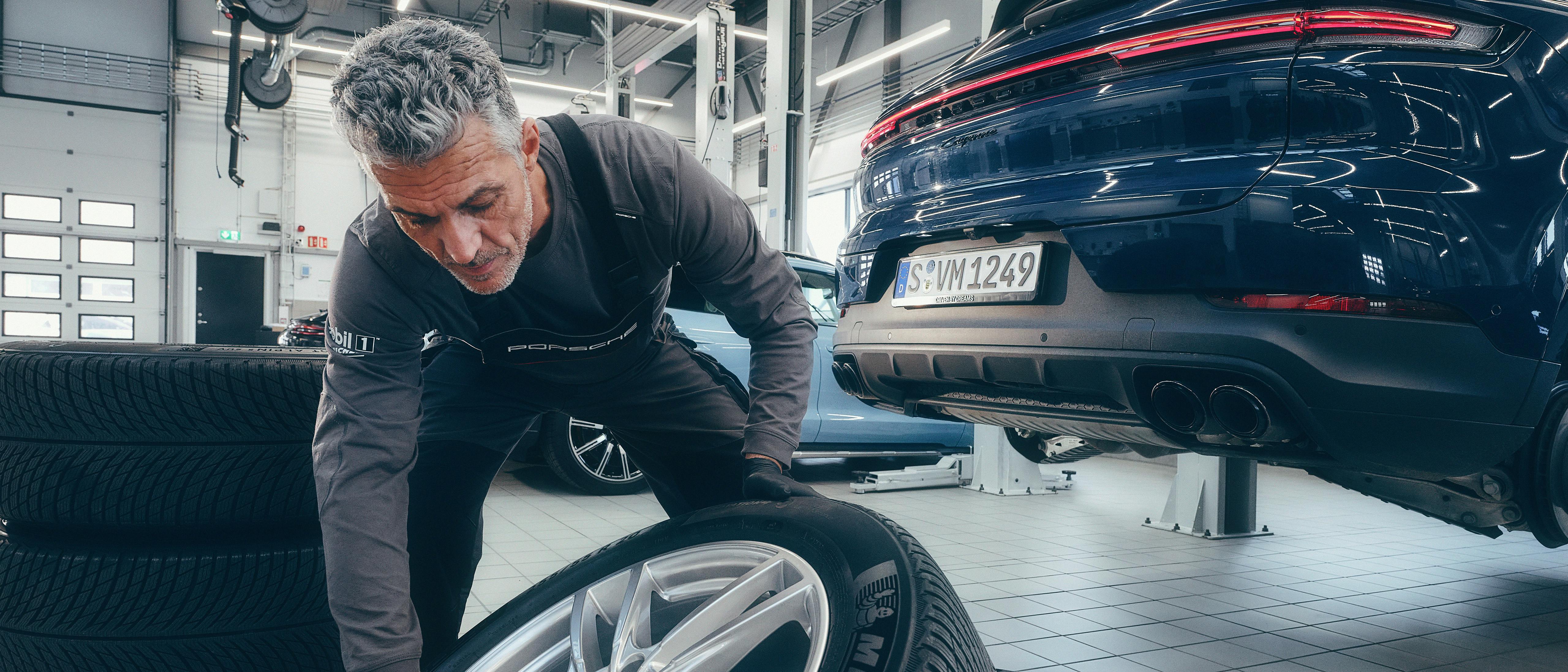 A Porsche workshop employee changes the tyres of a Porsche Cayenne