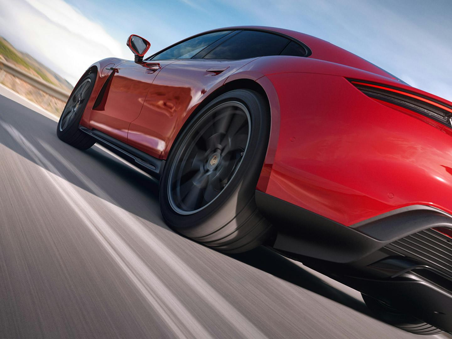 Dynamische Nahaufnahme der hinteren Seitenpartie eines roten Porsche Taycan.