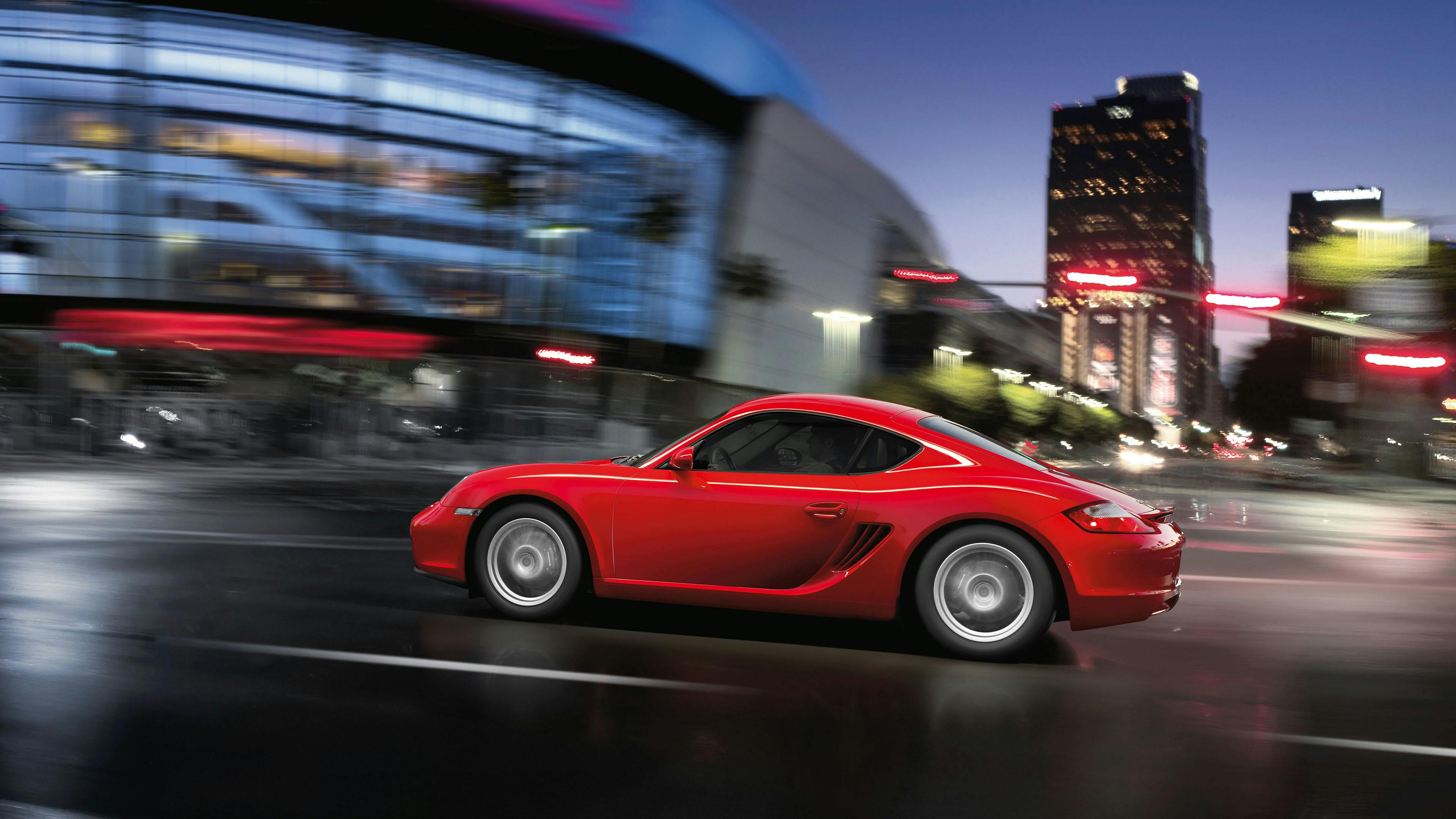 Cayman de color Rojo con motor de 2.7 litros circulando por un entorno urbano.