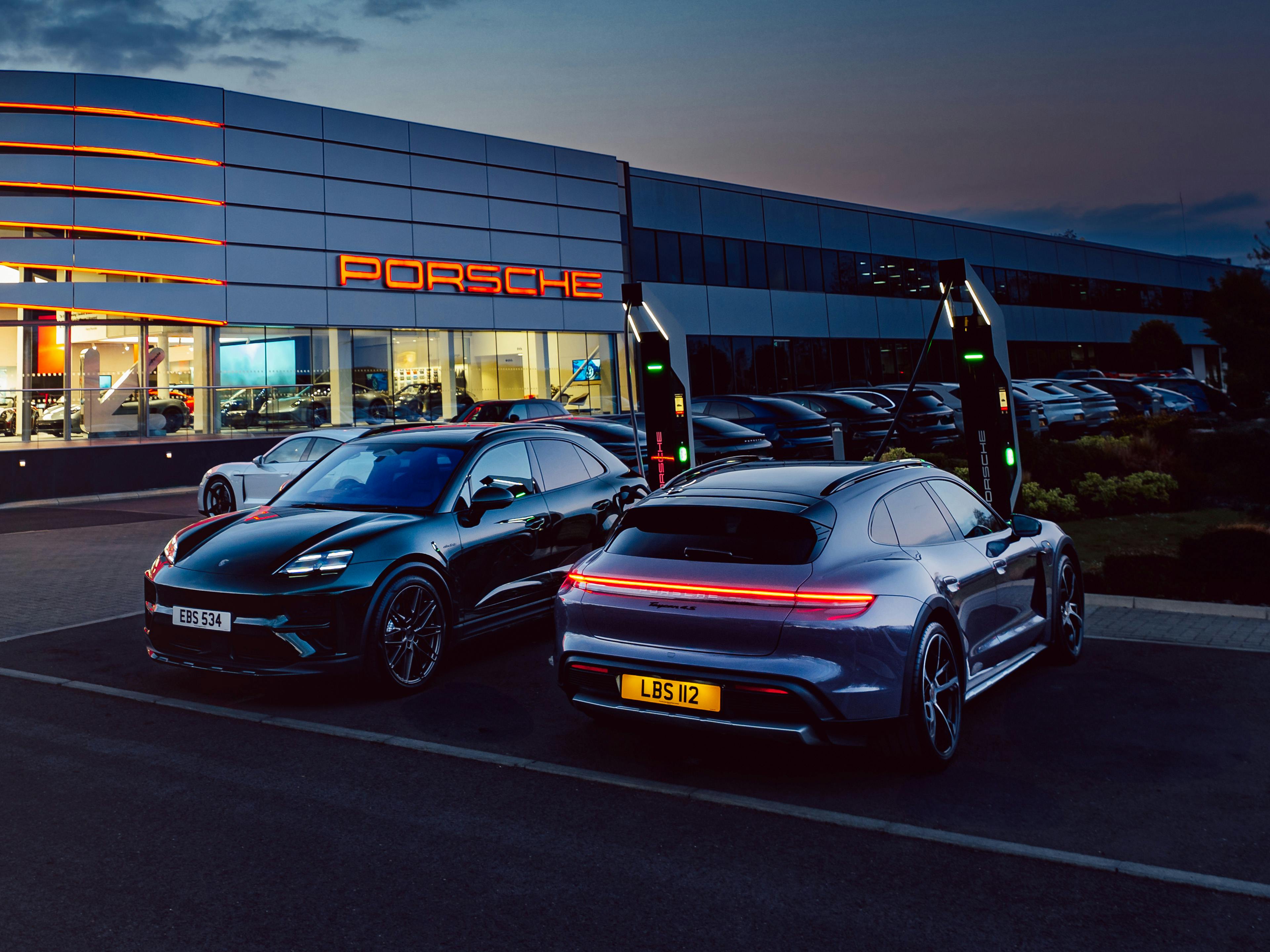 Porsche Macan Electric and Porsche Taycan parked next to the ultra-rapid turbo chargers at Porsche Centre Reading.