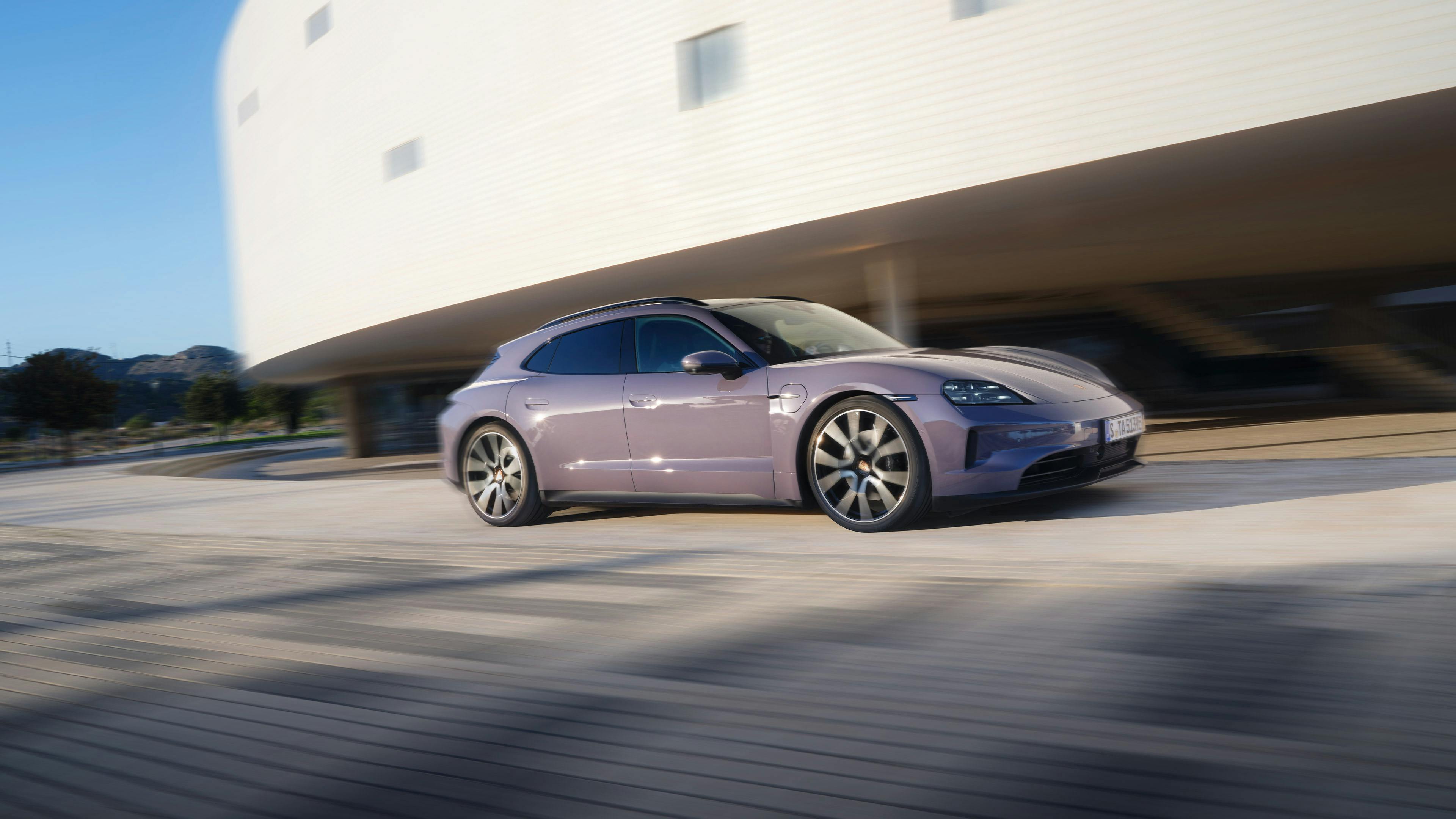 A Porsche Taycan 4S Sport Turismo at a drive along a modern building.