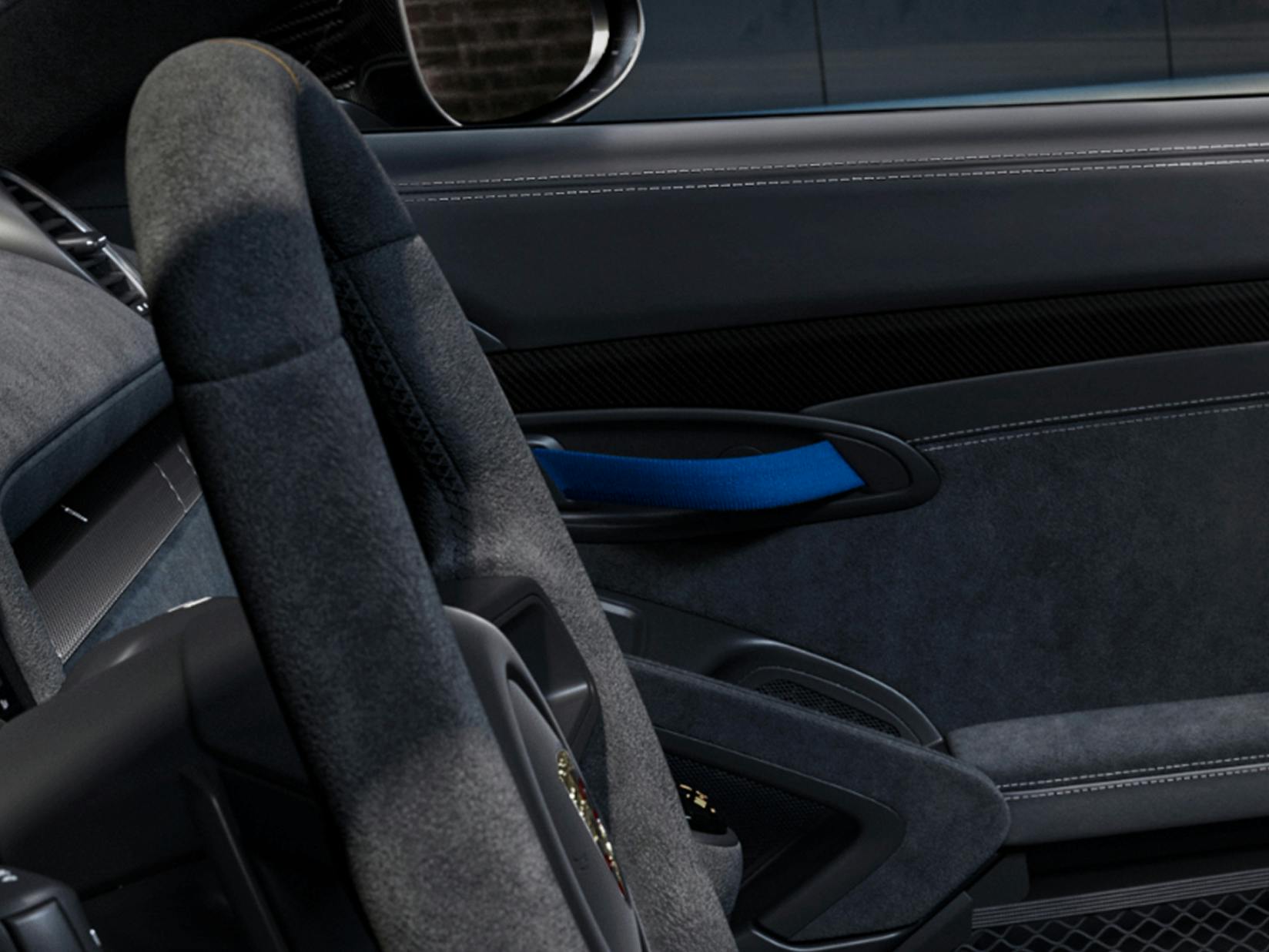 Detailed view of the door pull loops and the steering wheel in the Porsche Exclusive Manufaktur 718 Spyder RS.