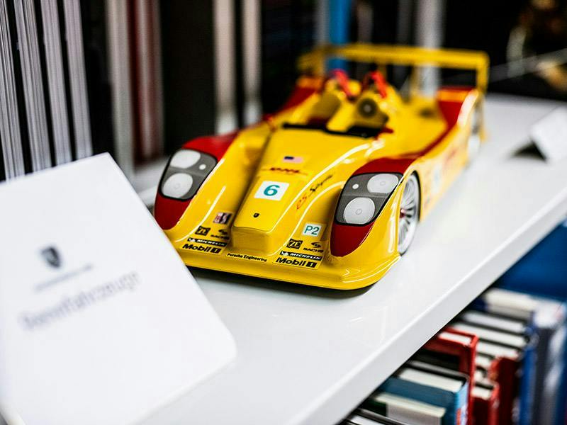 A Porsche racing car and fold-out book with information about Porsche vehicles